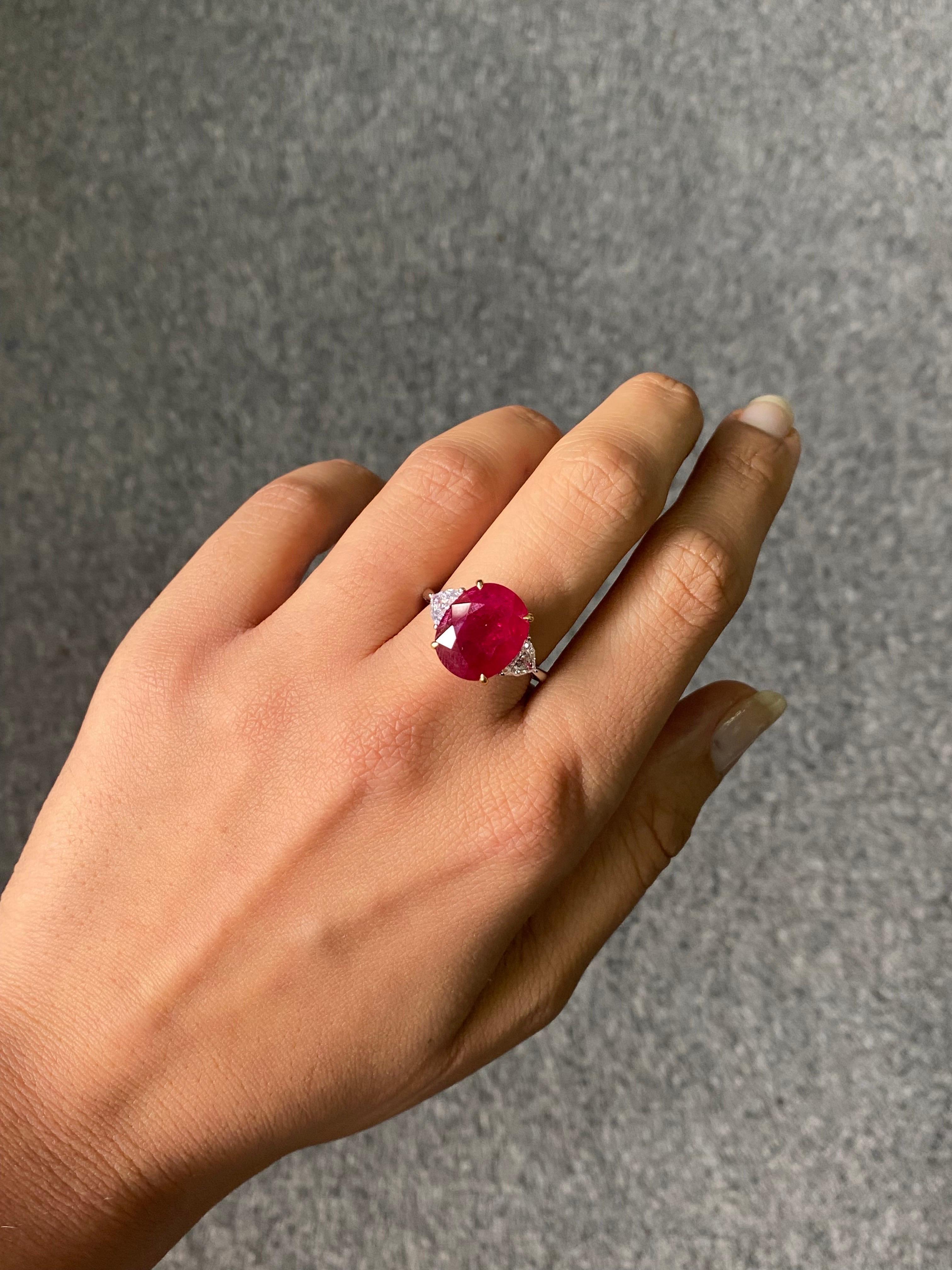 A stunning 8.11 carat certified natural, Mozambique Ruby, vivid red color and transparent. The center piece is adorned with 0.63 carat half moon side stone Diamonds, VS quality, G color. The ring is currently sized at US 7, can be resized. We