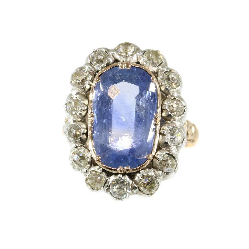 An antique engagement ring in 18 karat rose gold and silver set with one certified natural vivid light blue untreated sapphire weighting 9.35 carat and 14 old brilliant cut diamonds totaling 1.40 carat (colour and clarity: J/L, si/i).

Top of ring