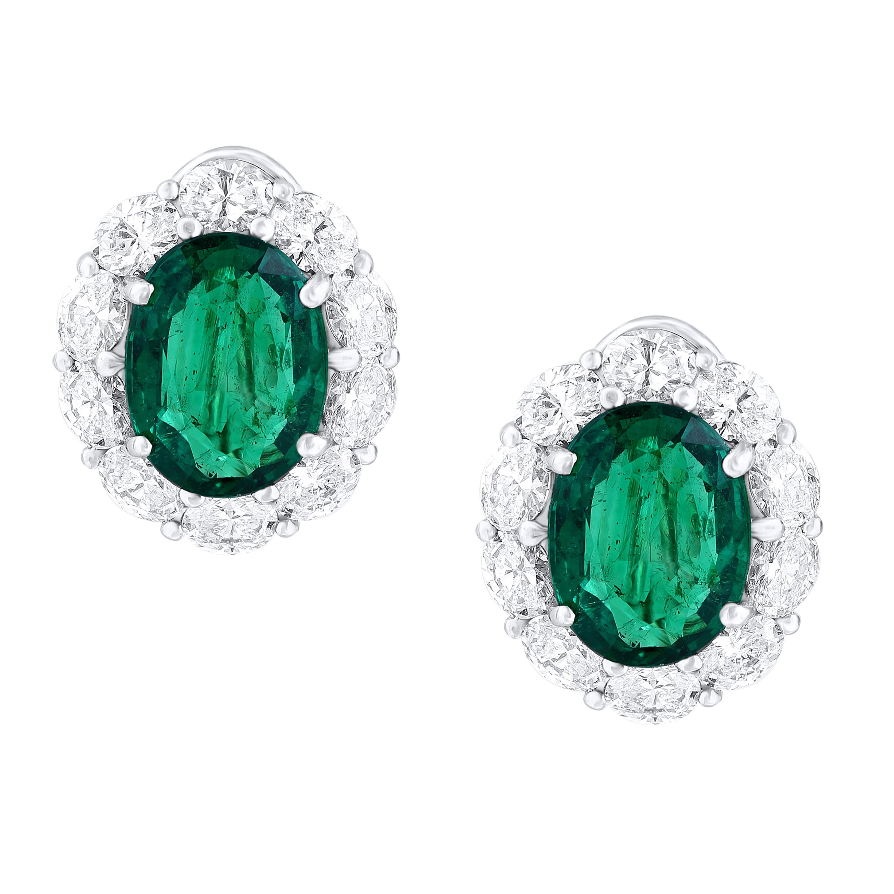 Showcasing two color-rich Certified oval cut Emeralds weighing 9.70 carats total, surrounded by a single row of oval cut brilliant diamonds. 20 Accent diamonds weigh 5.21 carats total. Set in 18 karats white gold. Omega Clip with the post.

Style