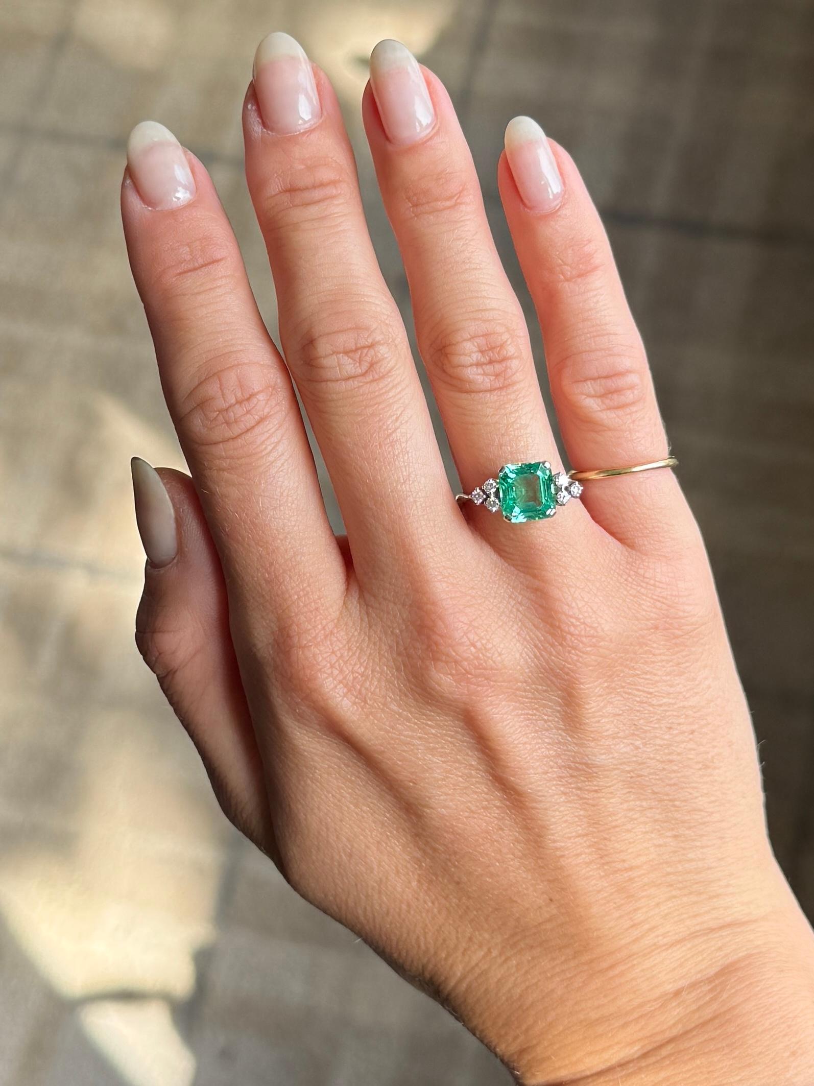 The Emerald in this ring is a natural, non heat treated Columbian stone and measures 2.2ct. It is the most stunning green colour. Either side sits a trio of diamonds, the diamond total is approx 25pts. The ring is modelled out of 18ct white gold and