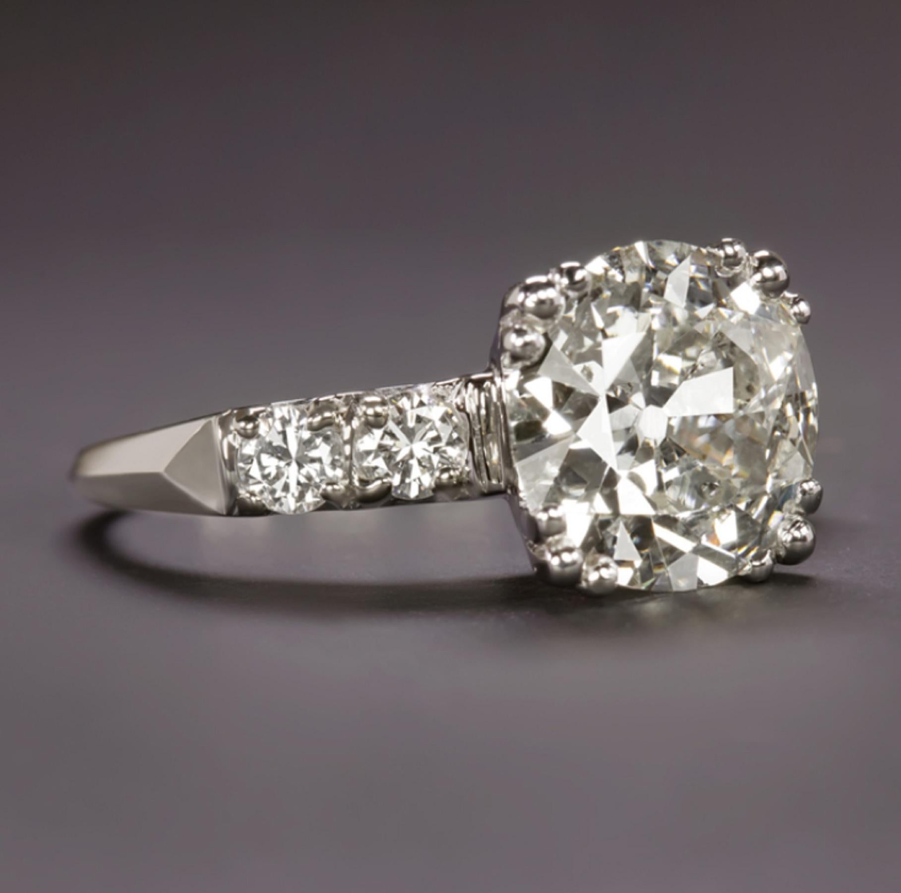 classic vintage engagement ring is dazzling with brilliant sparkle and beautifully crafted in solid platinum with simple yet elegant details. The 3.28ct old European cut certified diamond is impressive in size, beautifully white, eye clean, and