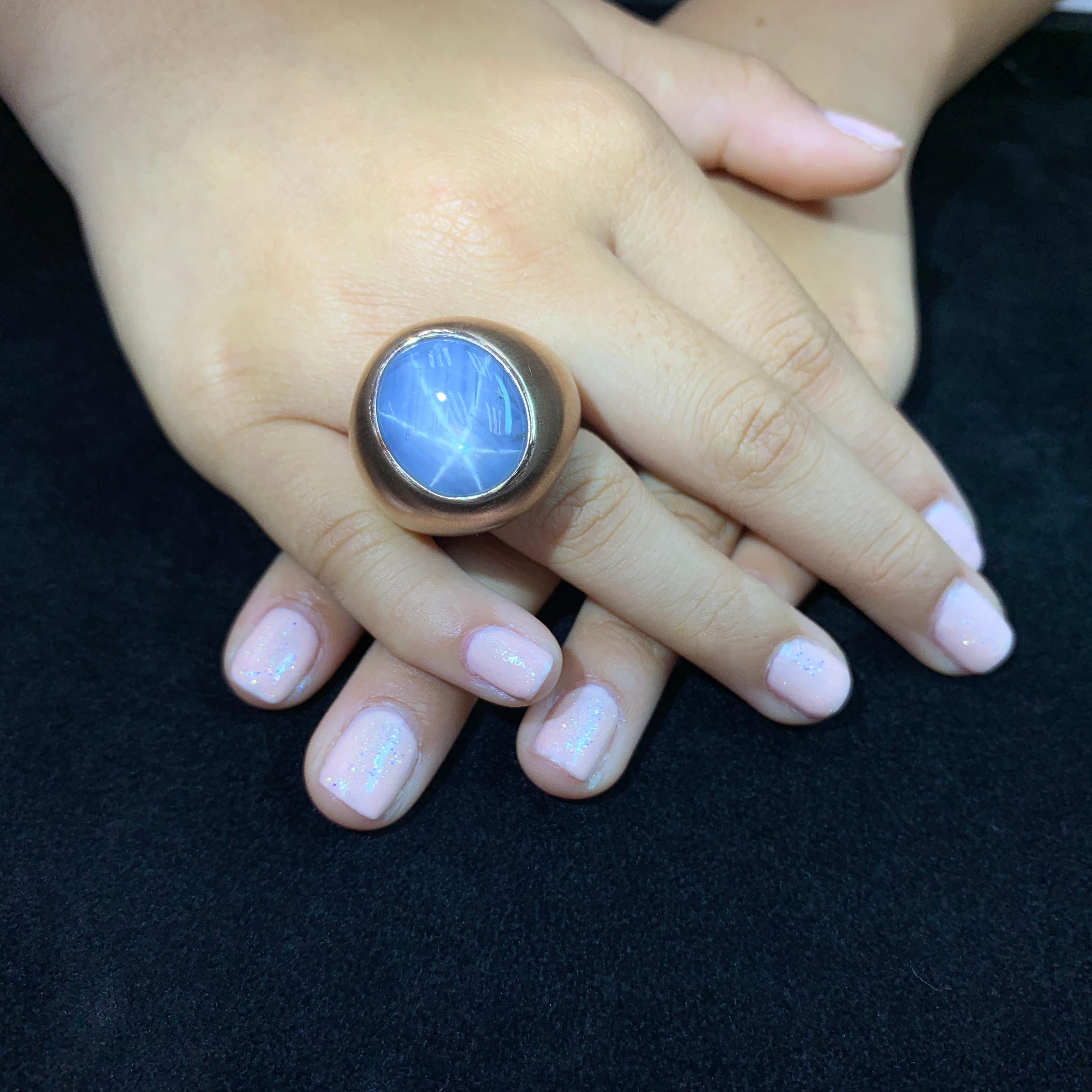 Here is a certified natural light blue star Sapphire rose gold ring. The ring is set in 18k rose gold. The ring is simple but makes a big statement! The almost 40 Cts star sapphire is impressive. The star is centered and very strong especially in