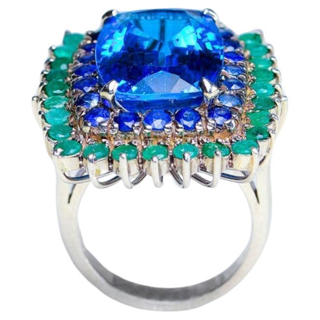 Contemporary Custom Platinum Blue Topaz Cocktail Ring with Emerald and Sapphire Halo For Sale
