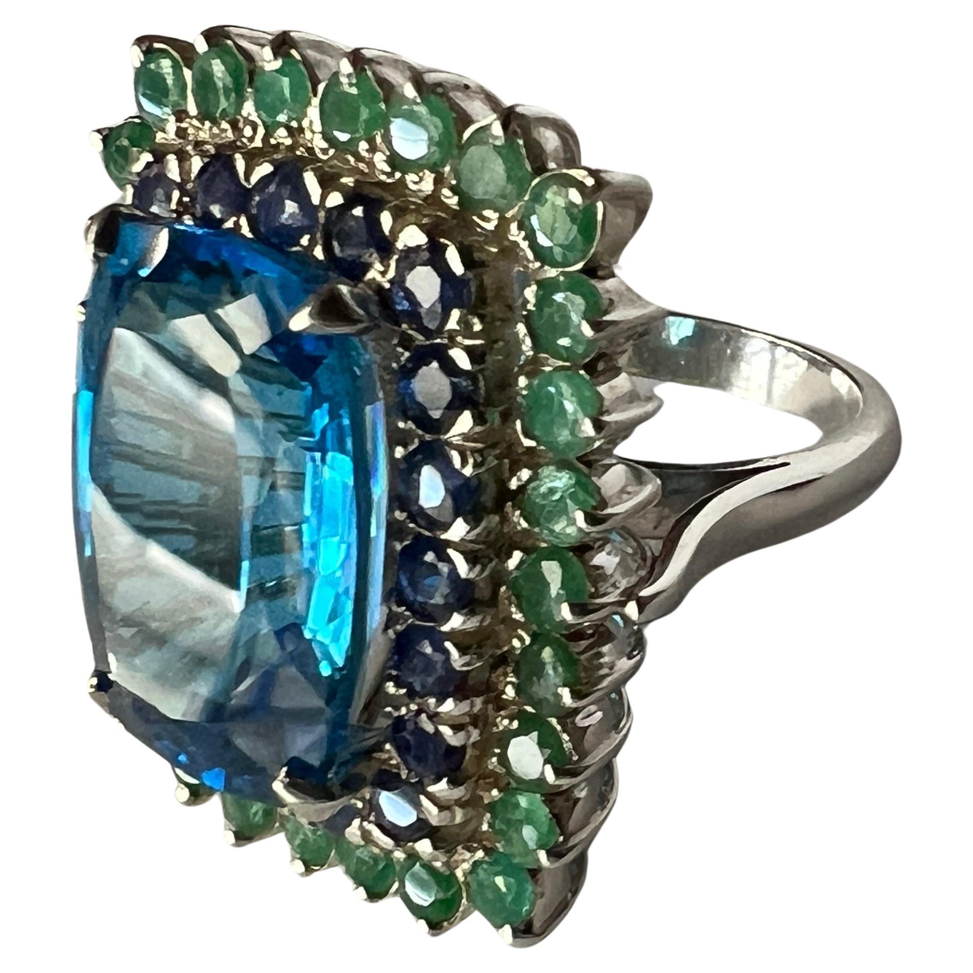 Custom Platinum Blue Topaz Cocktail Ring with Emerald and Sapphire Halo In New Condition For Sale In Lanham, MD