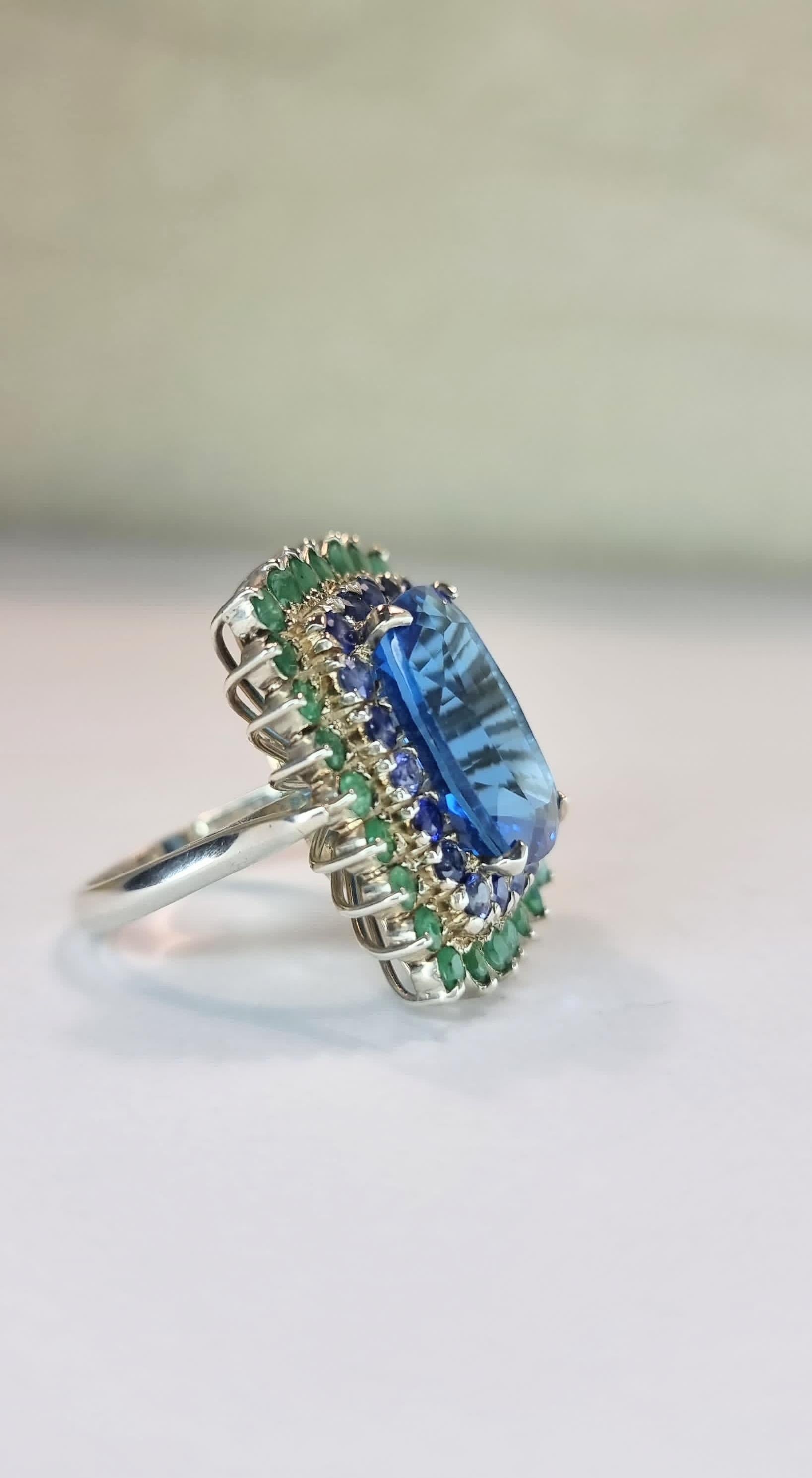 Women's Custom Platinum Blue Topaz Cocktail Ring with Emerald and Sapphire Halo For Sale
