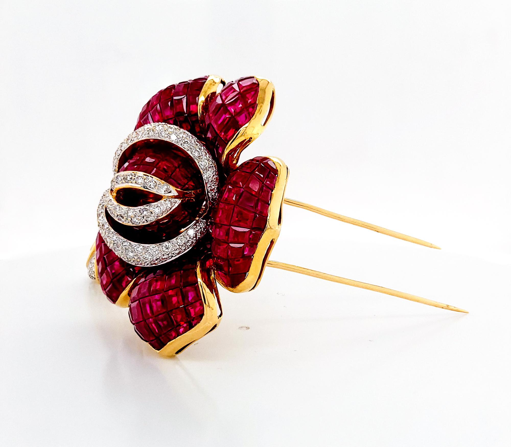 An incredible vintage brooch embellished with the invisibly-set rubies and pave diamonds. Circa 1970.
The brooch is certified by C.Dunaigre (Switzerland) stating that the rubies are Burmese with no indication of heating. 
The metal is 18K yellow
