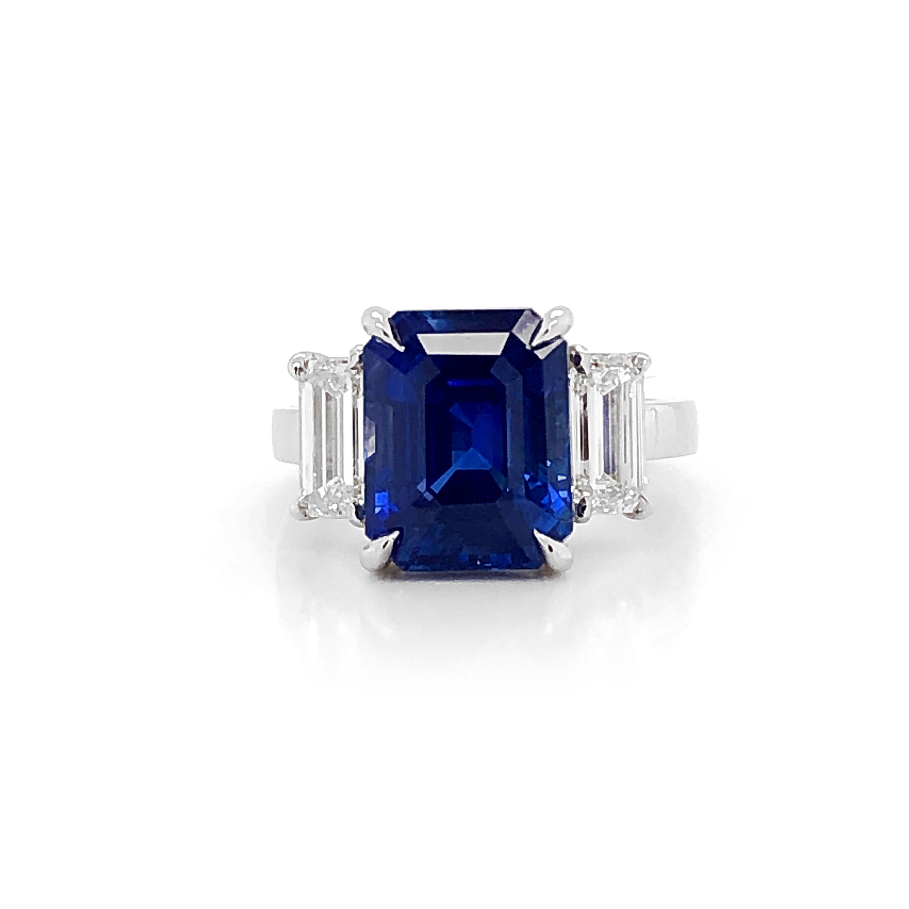 Handcrafted gemstone ring holds an emerald cut Ceylon sapphire 8.76 ct center stone. Sapphire is C. Dunaigre Switz Certified.  It is accented at either sides by baguette cut natural diamonds 1.41 ct in G-H Color Clarity VS on a platinum 950 metal