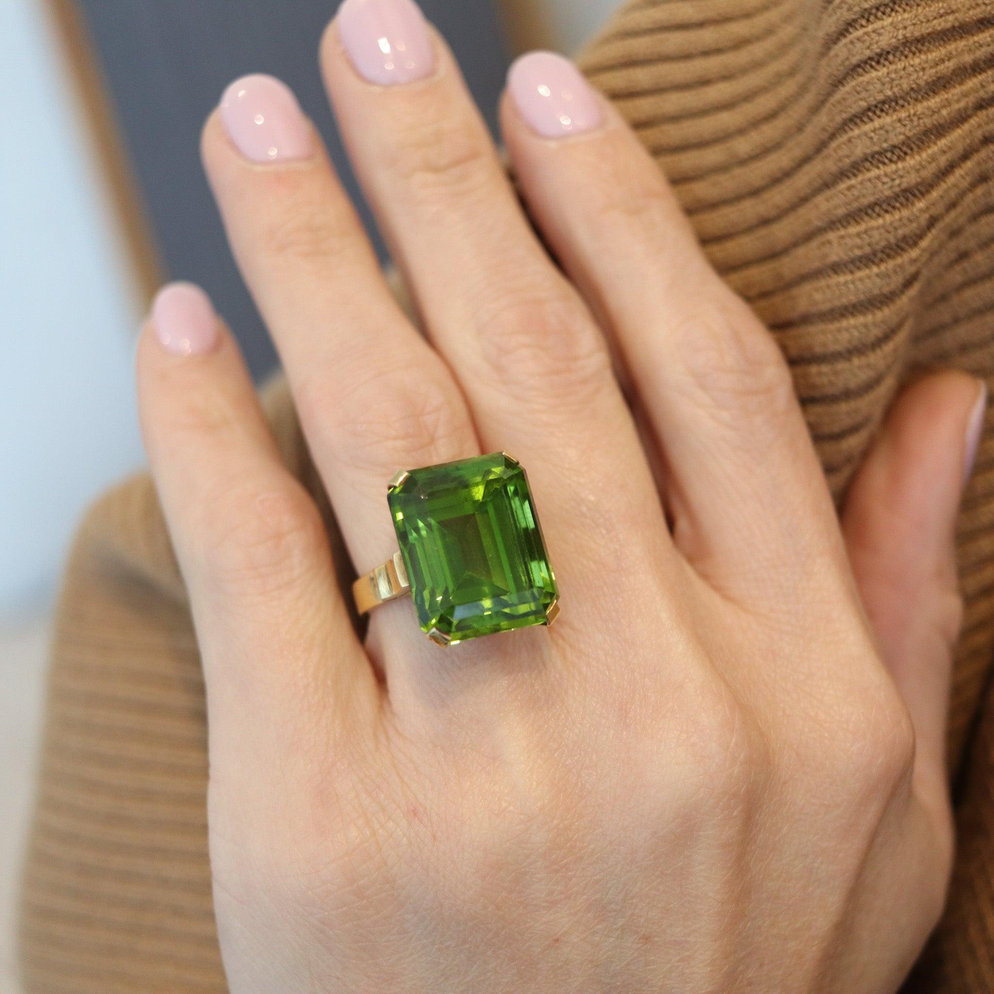 A cocktail ring with large precious peridot.

This is a modernist cocktail ring created with classic patterns, back in the late 1970's. The ring has been crafted in America as a large solitaire in solid yellow gold of 18 karats with high polished