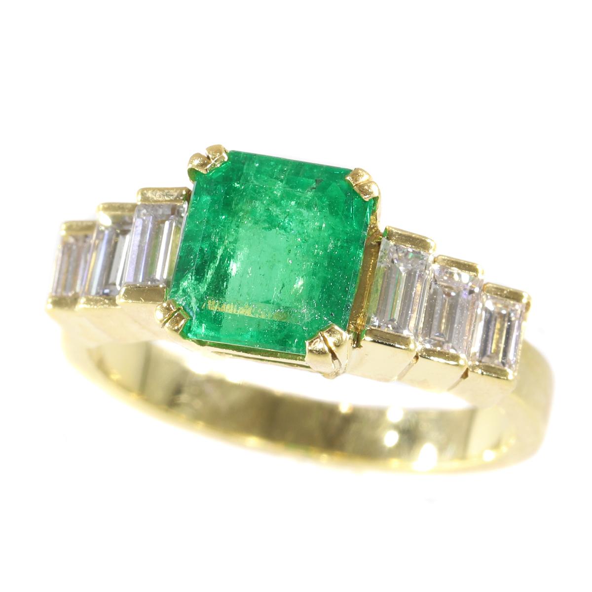 This 18K yellow gold French estate ring from the 1980's seems to have emerged from an exotic cascade with a grand square cut Colombian emerald of superb quality arising between six terraced baguette cut diamonds. With this gemmed force of nature