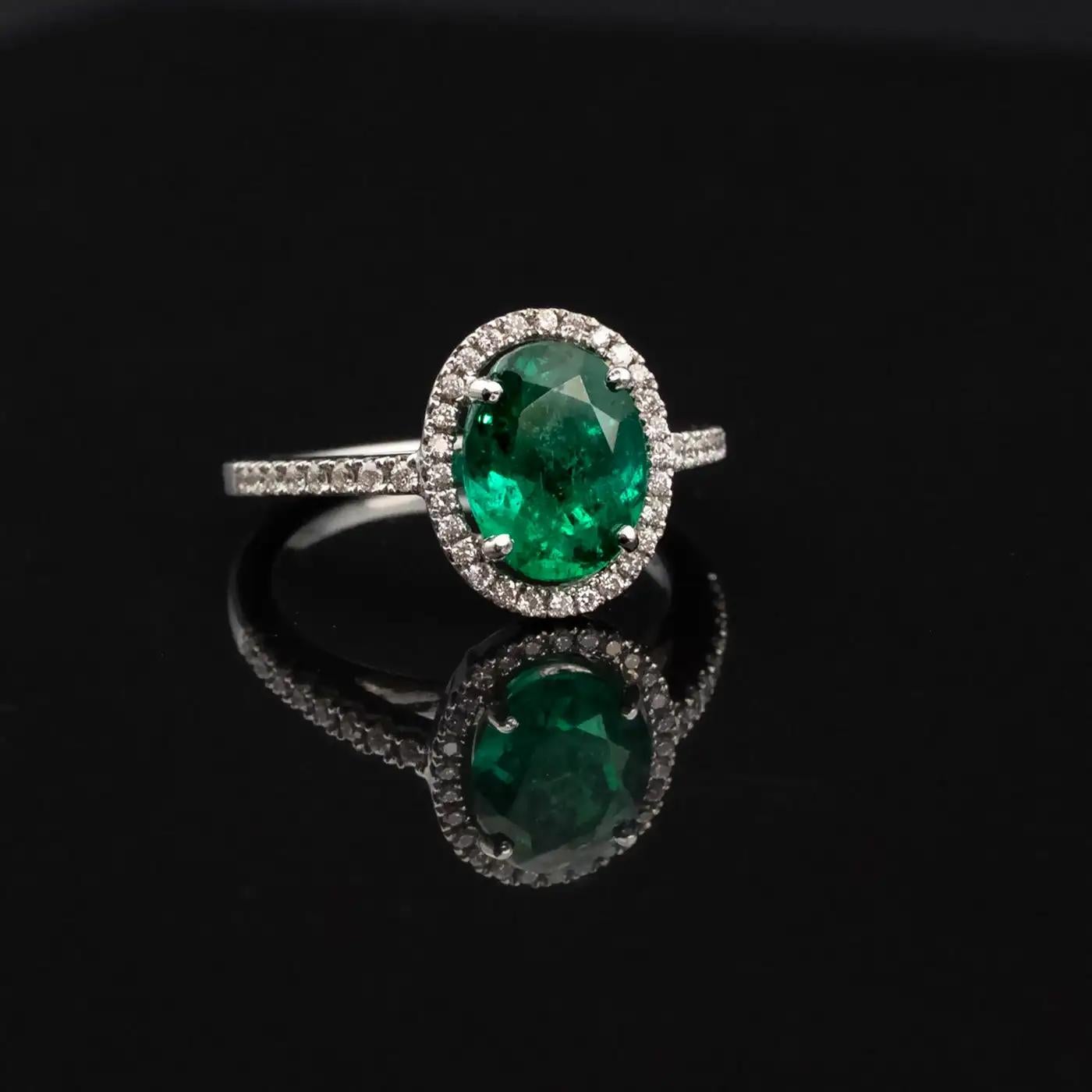 This exquisite engagement ring is a testament to refined elegance, featuring a 1.62ct oval-cut Colombian emerald, renowned for its rich, vivid Muzo green hue. Certified by Bellerophon, a reputable French independent laboratory, this emerald is
