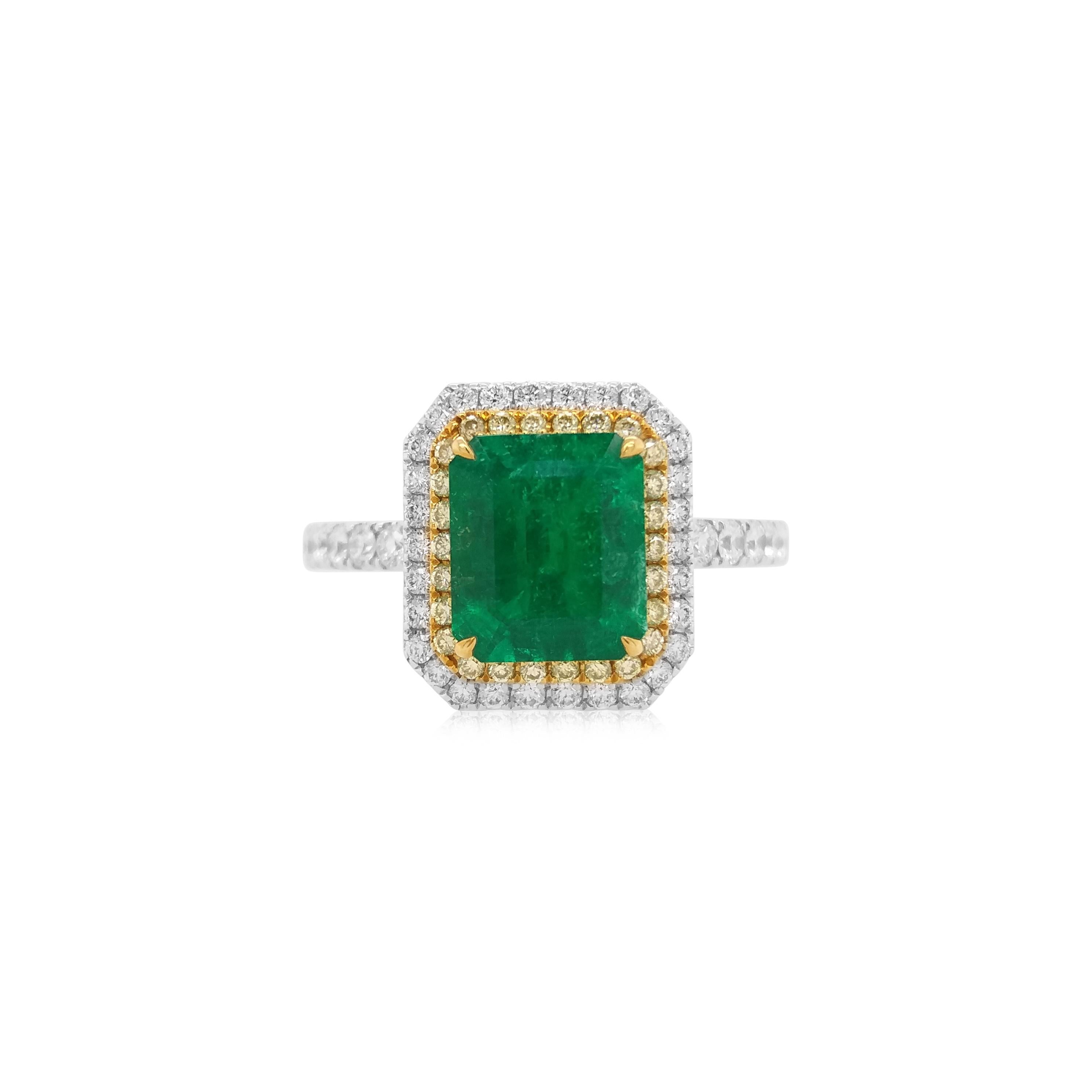 Dieser klassische Ring ist eine einzigartige Mischung aus Innovation und Eleganz. Im Mittelpunkt steht ein kolumbianischer Smaragd im Smaragdschliff, der für seinen lebhaften grünen Farbton und seine außergewöhnliche Klarheit bekannt ist. Flankiert