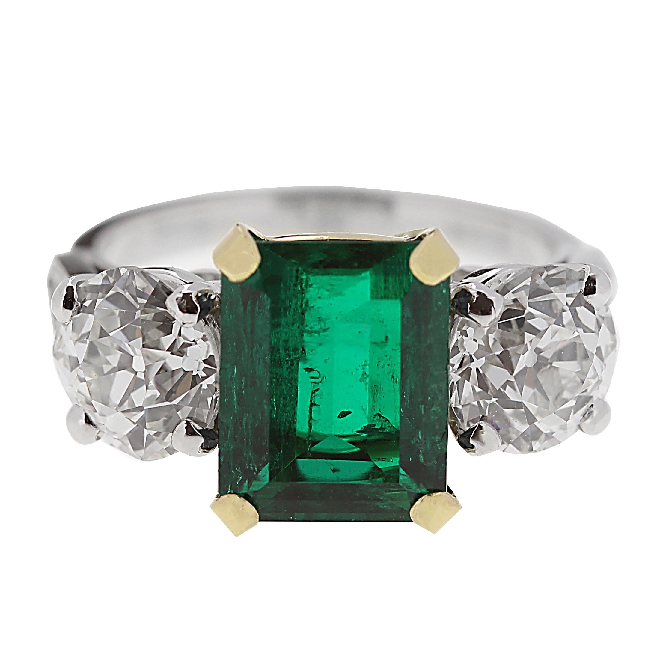 Not your average, but a bold emerald and diamond ring, full of life and sparkles. It’s a rectangular emerald gem encased in gold on a platinum ring. Might I also mention that on the shoulder of the emerald are two old European cut diamonds which