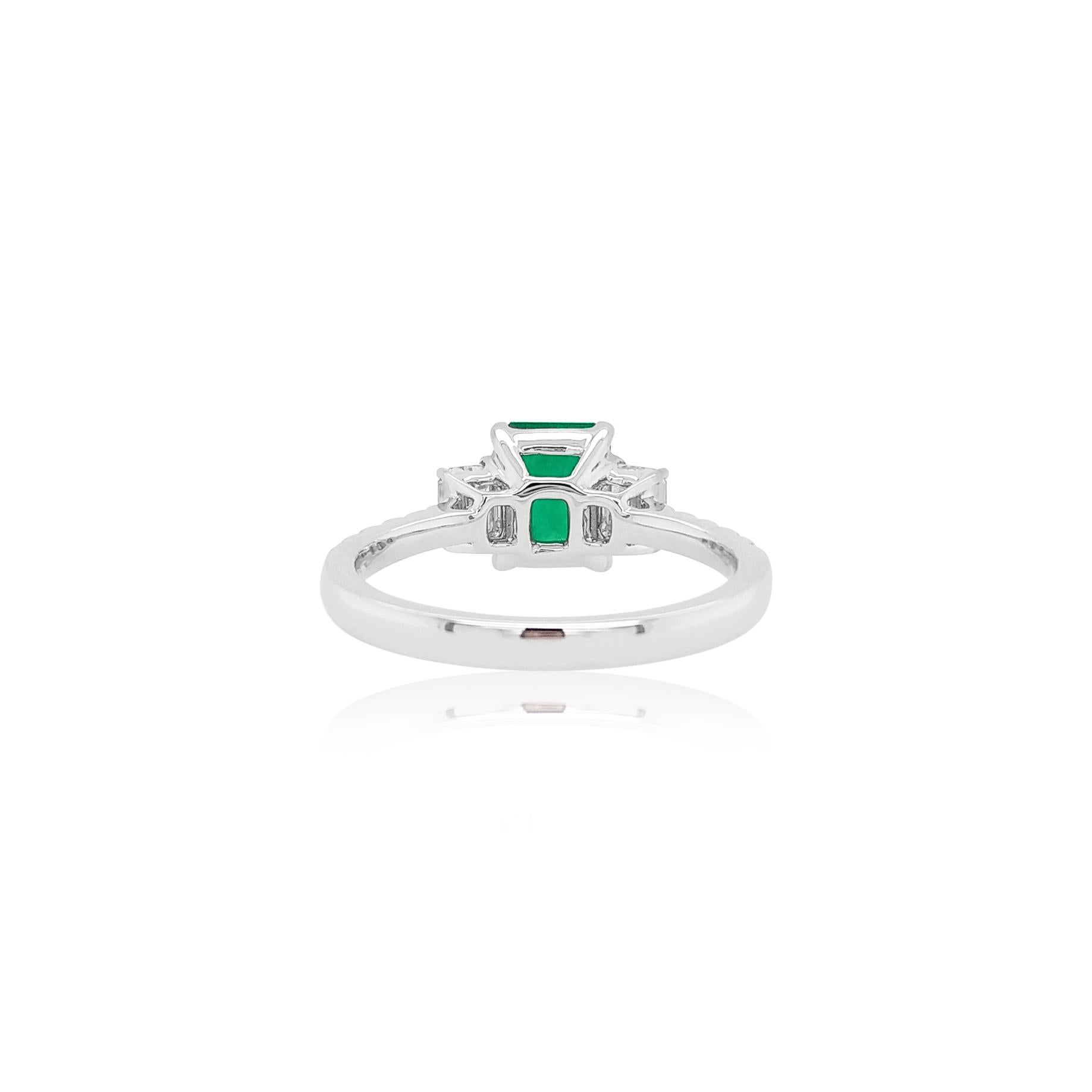 This delicate ring features a exceptional Emerald-cut Colombian Emerald at the forefront of its design. The spectacular hues of the Emerald are perfectly accentuated by the 18 Karat White Gold setting and elegant Emerald-cut White diamond on its
