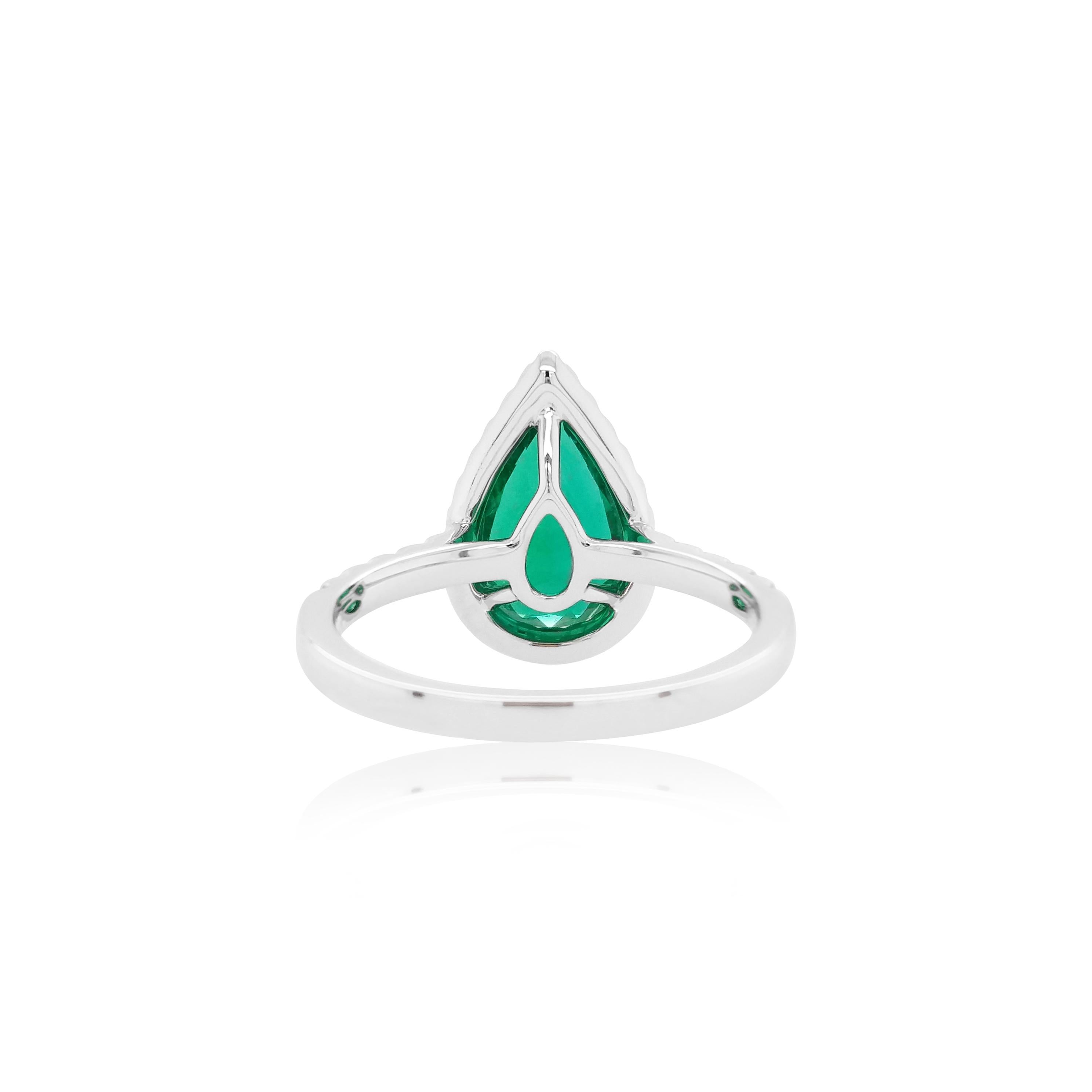 This elegant ring features a lustrous vivid green Pear-shape Colombian Emerald at its centre, with a delicate diamond halo surrounding it. Set in 18 Karat white gold to enrich the spectacular hues of the emerald and the sparkle of the diamonds, this
