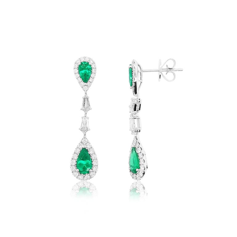 These playful earrings feature sumptuous natural Pear-shape Colombian Emeralds surrounded with scintillating white diamonds, and Kite-shape white diamonds arranged in stream motif. Perfect as a gift for a loved one or as a way to inject a subtle pop