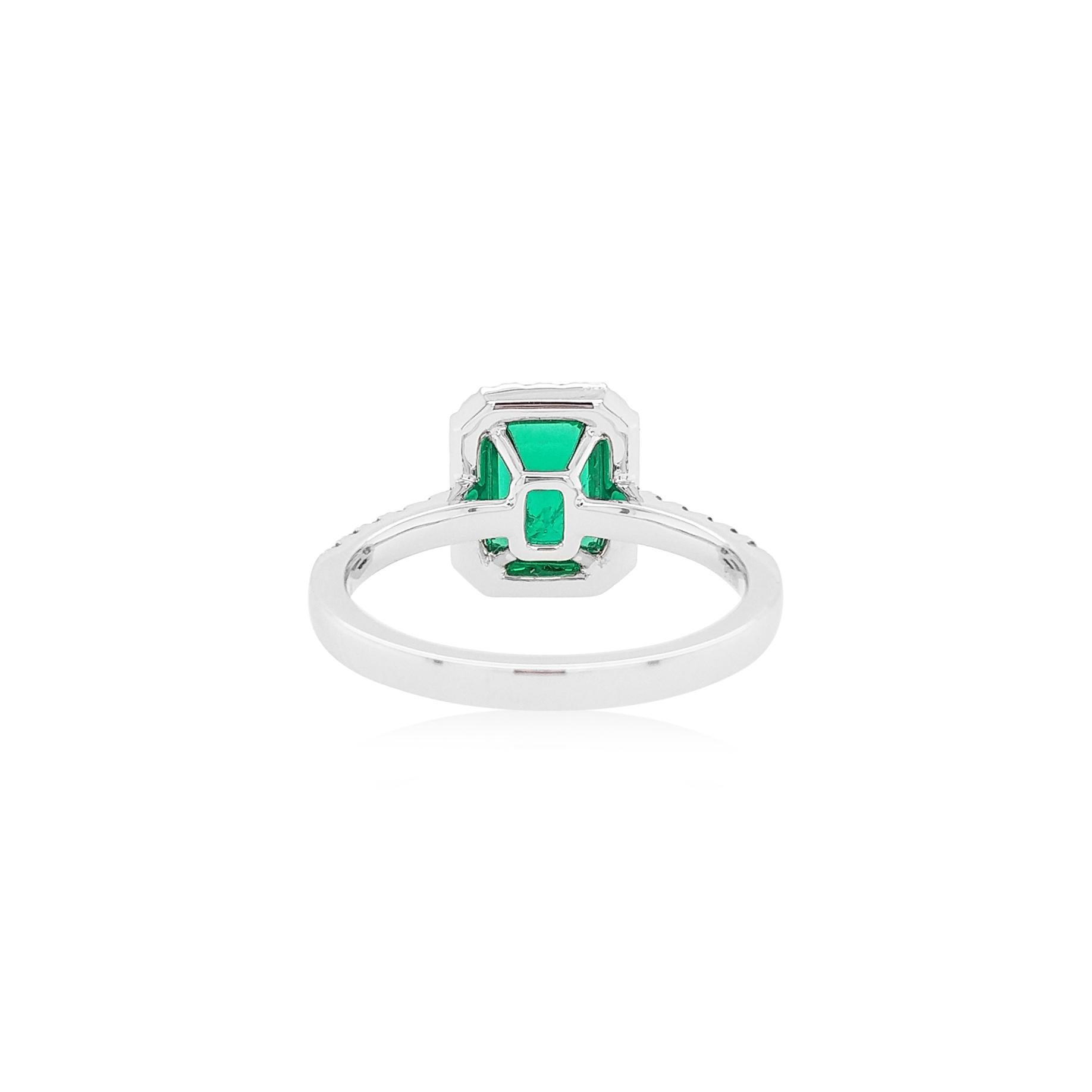 This elegant ring features vibrant Emerald-cut Colombian Emerald at its forefront, with a delicate white diamond halo surrounding them. Set in platinum to enrich the spectacular hues of the emerald and the sparkle of the diamonds, this ring utilizes