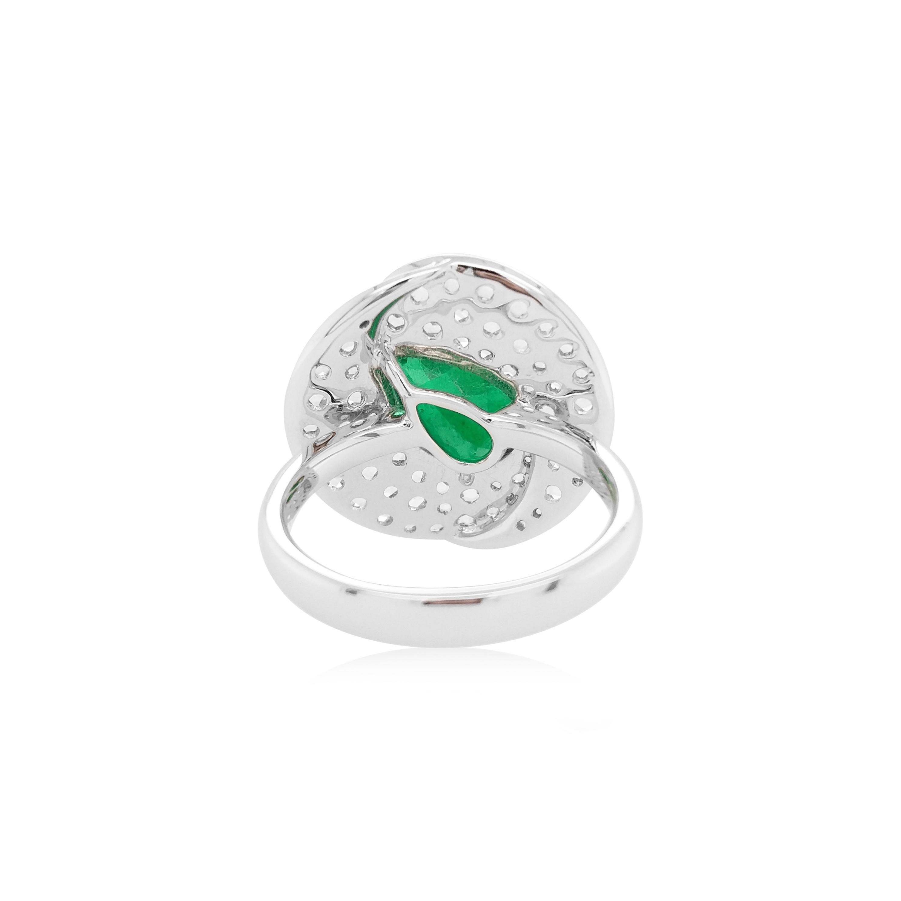 This contemporary ring features a vibrant pear-shaped Colombian Emerald at its centre, with a delicate arrangement of rose-cut white diamond surrounding it. Set in 18 Karat white gold to enrich the spectacular hues of the emerald and the sparkle of