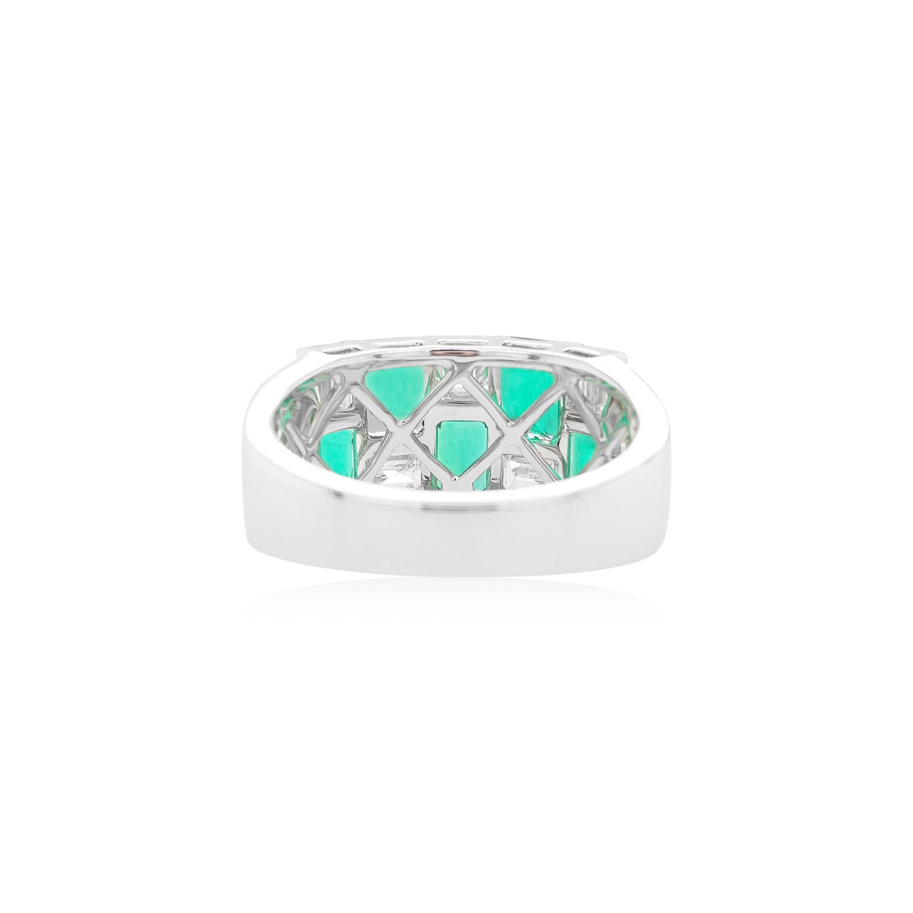 Dieses exklusive Cocktailringband besteht aus leuchtenden kolumbianischen Smaragden im Smaragdschliff, die zwischen funkelnden weißen Diamanten im Smaragdschliff gefasst sind. Auffällig und auffällig, gefasst in 18 Karat Weißgold, um die