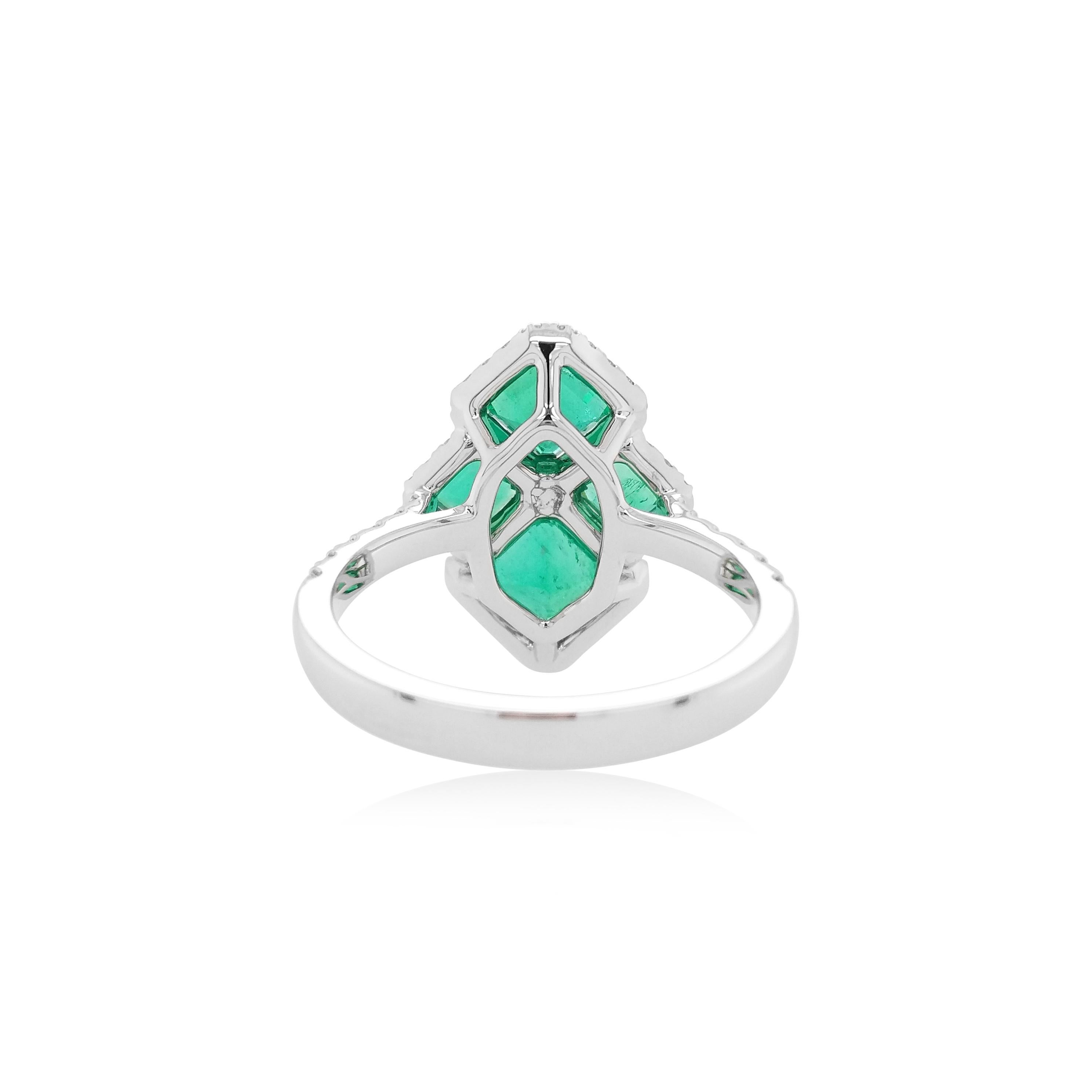 This sophisticated cocktail ring features vibrant emerald-cut Colombian Emeralds at its forefront, accentuated by delicate white diamond halos in amongst. Set in 18 Karat white gold to enrich the remarkable hues of the emerald and the sparkle of the