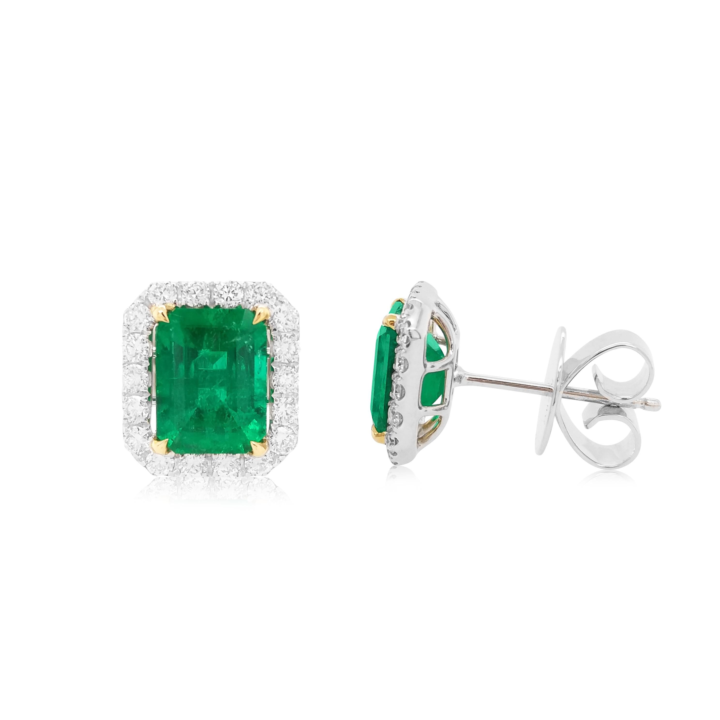 These elegant earrings feature lustrous emerald-cut Colombian Emeralds at the heart of the design, surrounded by a halo of scintillating white diamonds. Bold and striking, set in 18 Karat white and yellow gold to enrich the spectacular hues of the