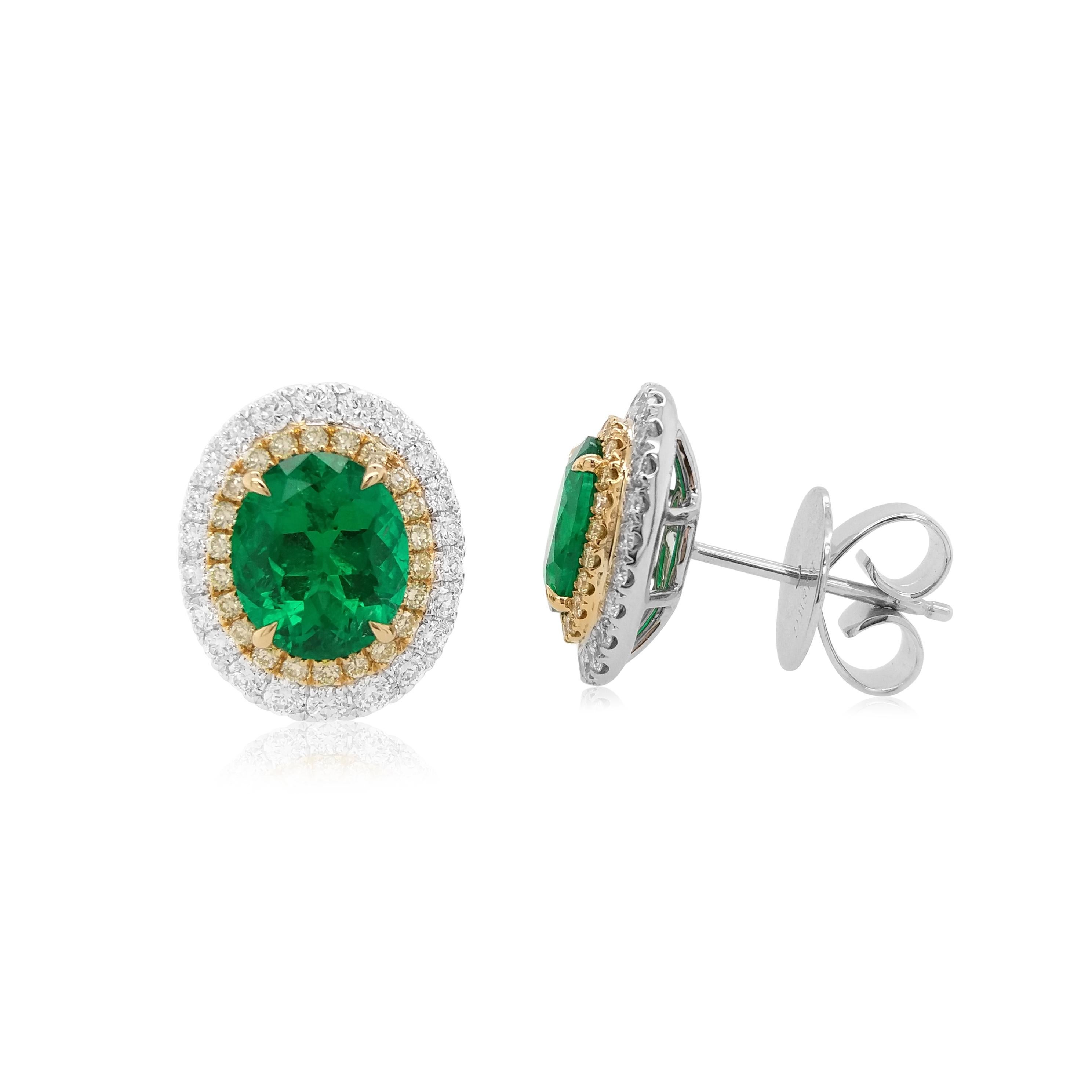 Faites-vous remarquer avec ces boucles d'oreilles exquises composées d'émeraudes colombiennes de taille ovale, très prisées pour leur couleur et leur clarté exceptionnelles. Chaque émeraude est gracieusement encadrée par un halo de diamants jaunes