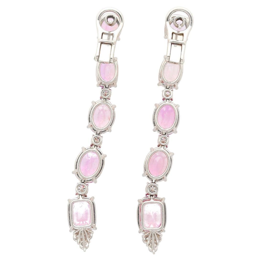 Platinum set Pink Sapphire and Diamond dangle earrings with lever back closure. The Sapphires feature a stunning color-changing effect, stones that exhibit different colors in different lighting conditions, giving you two very exciting colors under