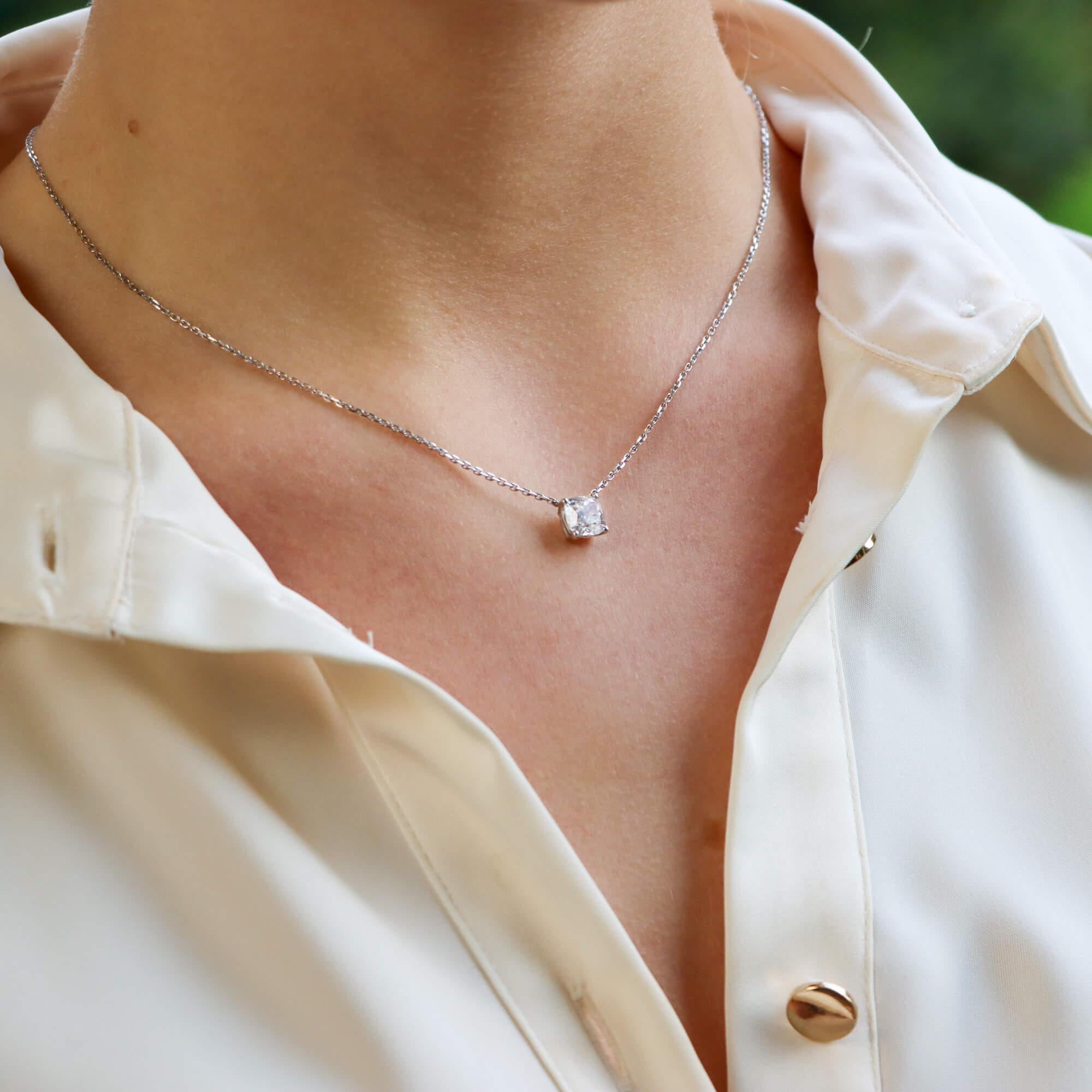 A beautiful solitaire cushion-cut diamond pendant necklace in 18-karat white gold. The pendant features a certified cushion brilliant-cut diamond which is claw-set in an open-back white gold setting. This stone has superb specifications being