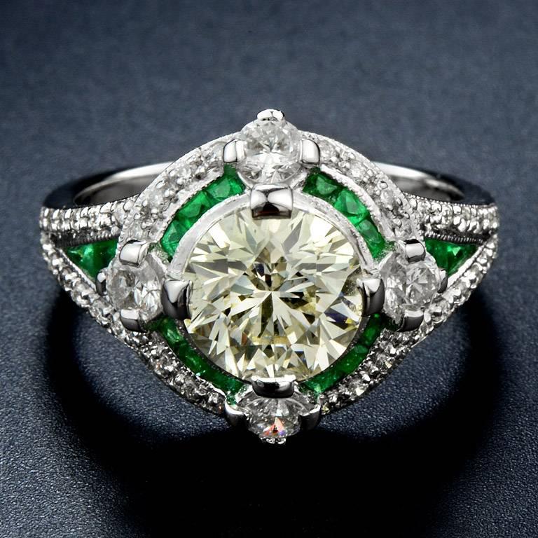 HKD Certified 2.01 Carat Weight Diamond M Color VS1 Clarity in the center. The halo was set with 12 pieces 0.42 Carat French Cut Emerald 4 pieces  0.44 Carat Round Cut Diamond and Sparkling Round Cut Diamond 40 pieces 0.30 Carat. 

This Ring was