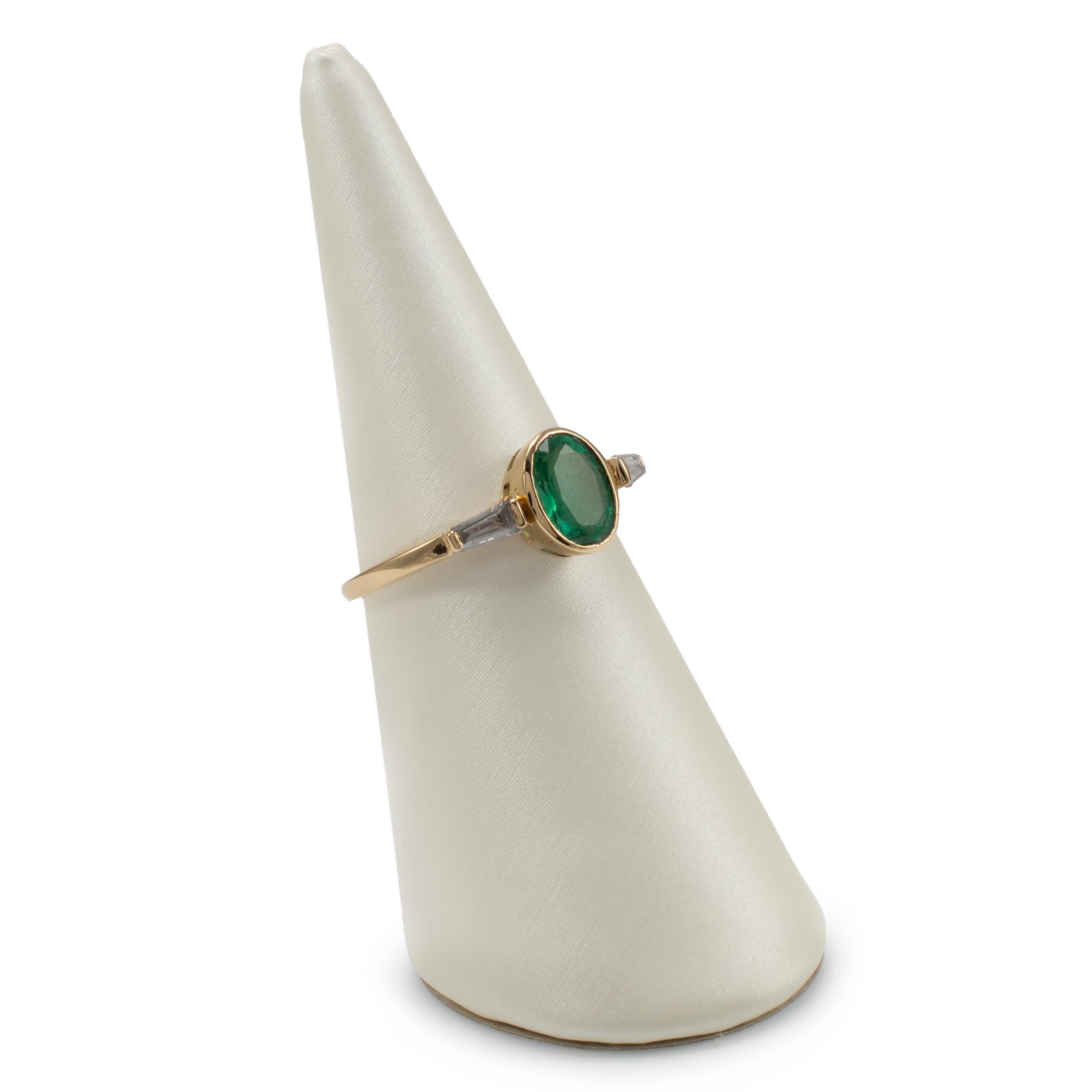 This gorgeous emerald and diamond dress ring is nicely crafted in 18 karat yellow gold. The bezel set oval cut emerald is complemented by tapered baguette diamonds set on each shoulder.

Ring Size: UK/AU size N  US size 7  EU size 54

Emerald with