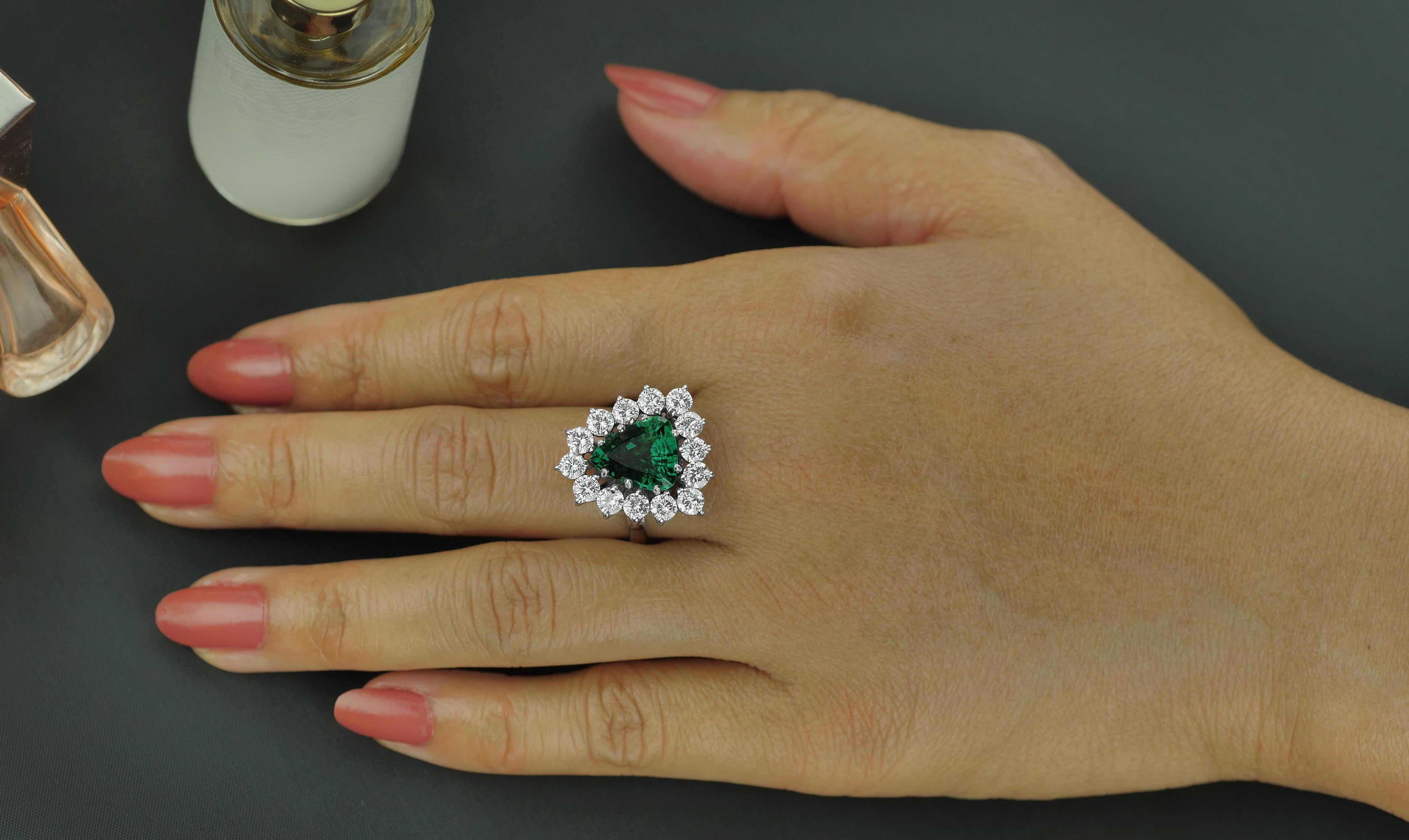 The remarkably clear depths of this 2.98 carat trilliant cut emerald cocktail ring is simply mesmerising. Its impressive proportions are complemented by round brilliant cut diamonds surrounding, meticulously set to focus the eye upon the hypnotic