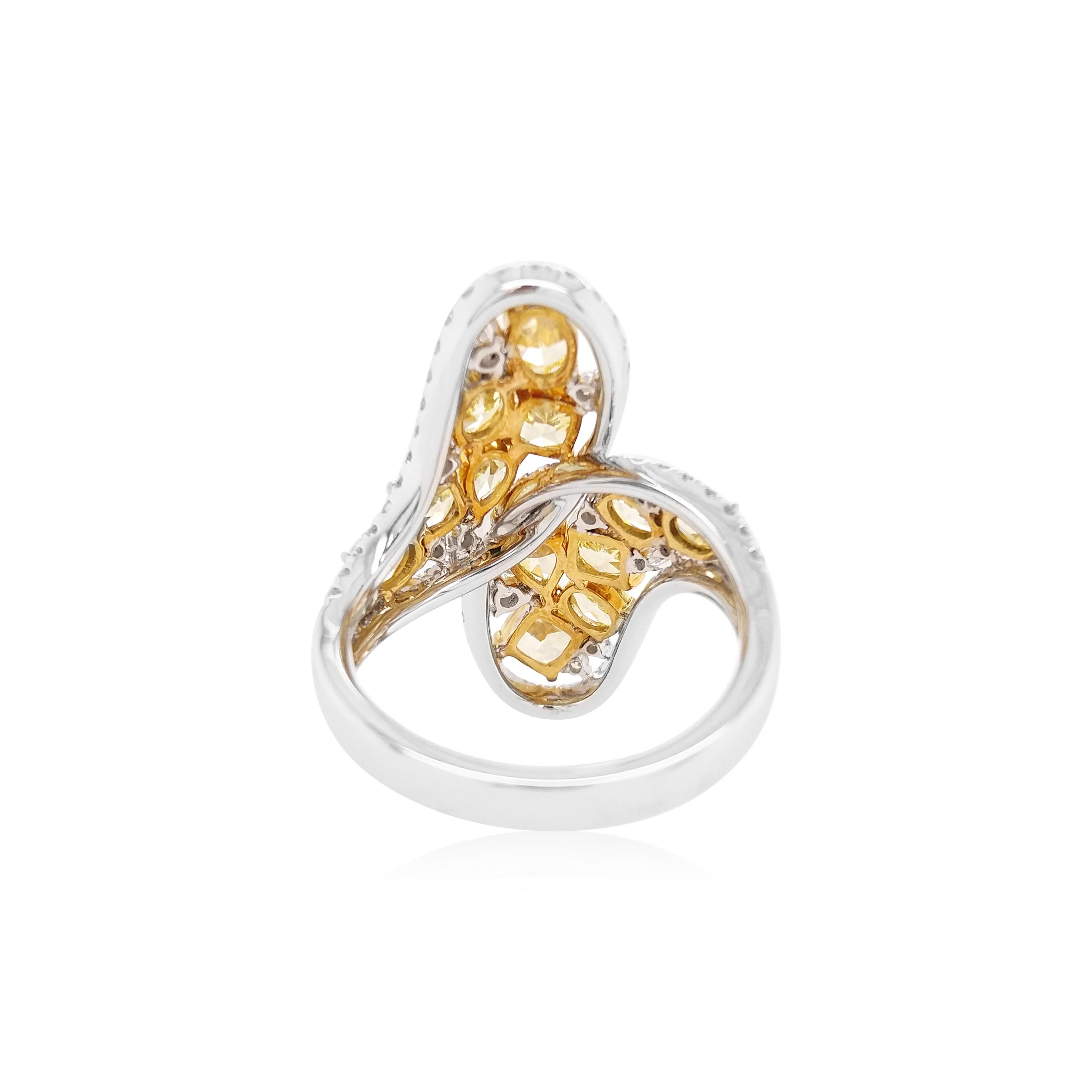 This stunning Platinum cocktail ring featuring an electric array of Fancy shapes Yellow Diamonds. The rich hues of the yellow diamonds are complimented perfectly by the sparkle of the white diamonds which surround it. This statement ring is a