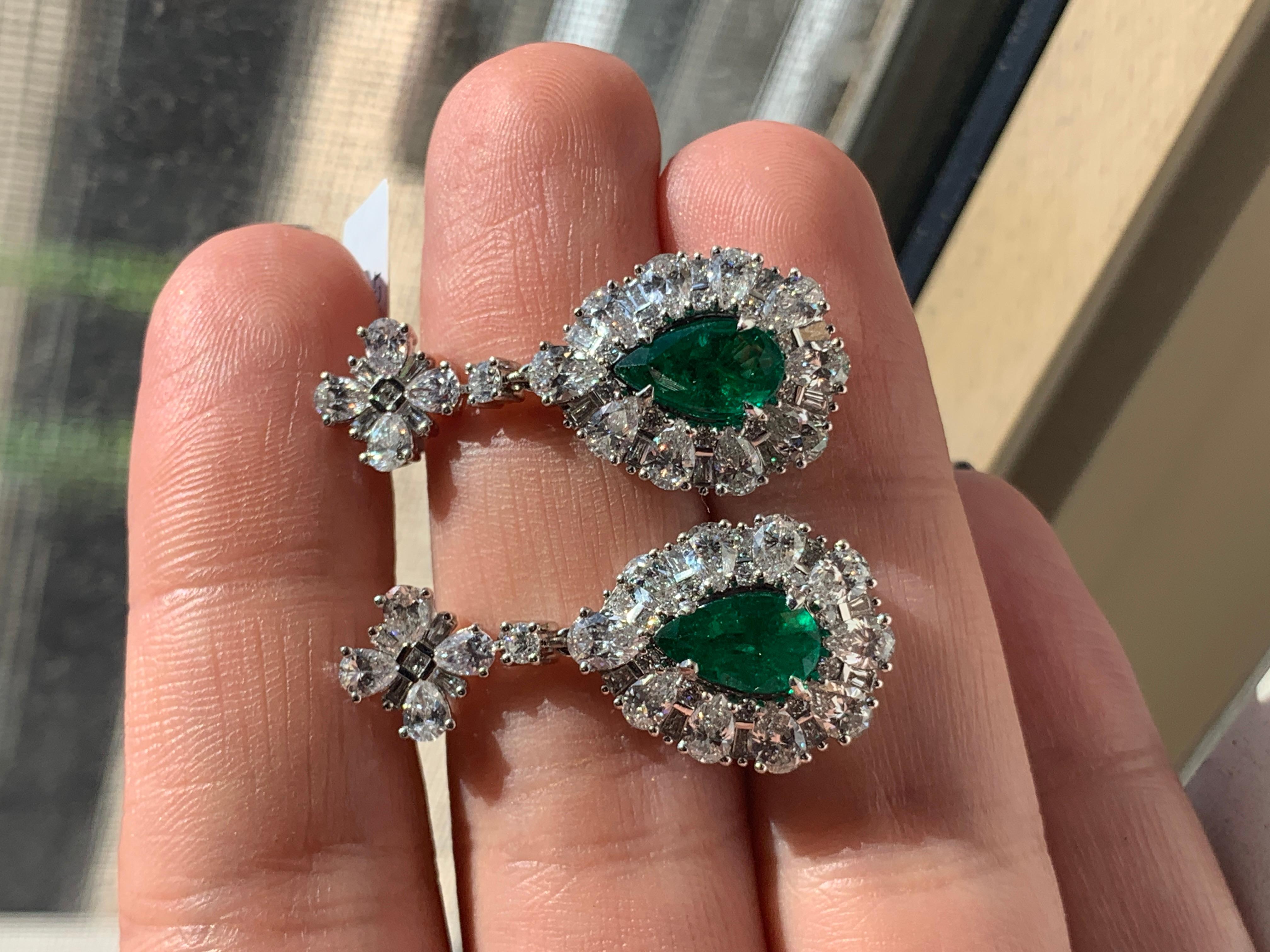 One 18K White gold Green Emerald and Diamond Earrings, stunning combination of white pear shape diamonds mixed with long baguette diamonds. 3.22 carats of green emeralds with 5.40 carats of diamonds. 
