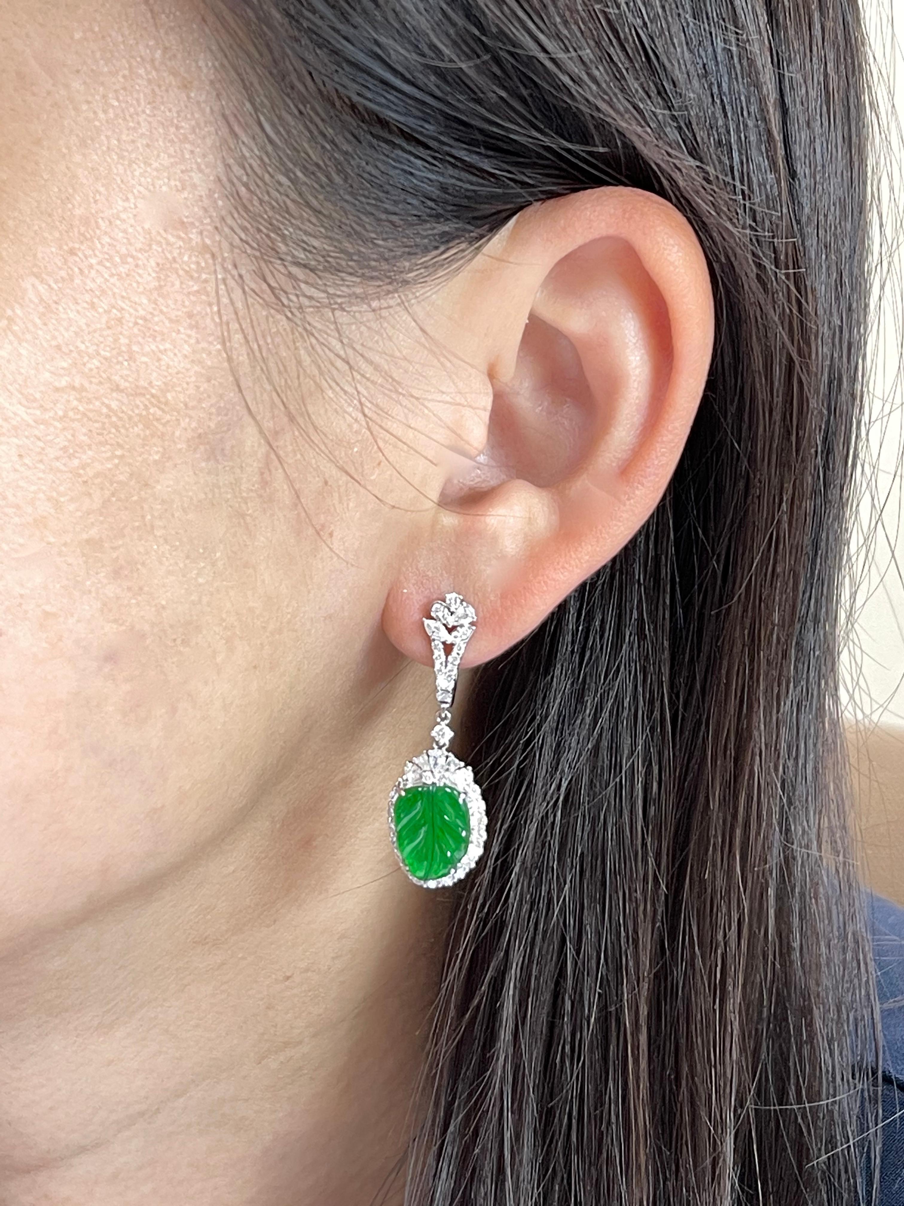 This is a very special pair of earrings. They GLOW! The jade in these earrings are certified by two labs to be natural jadeite jade. The earrings are set in 18k white gold. There are 2 carved apple green jade leaf motifs and 1.791cts of white