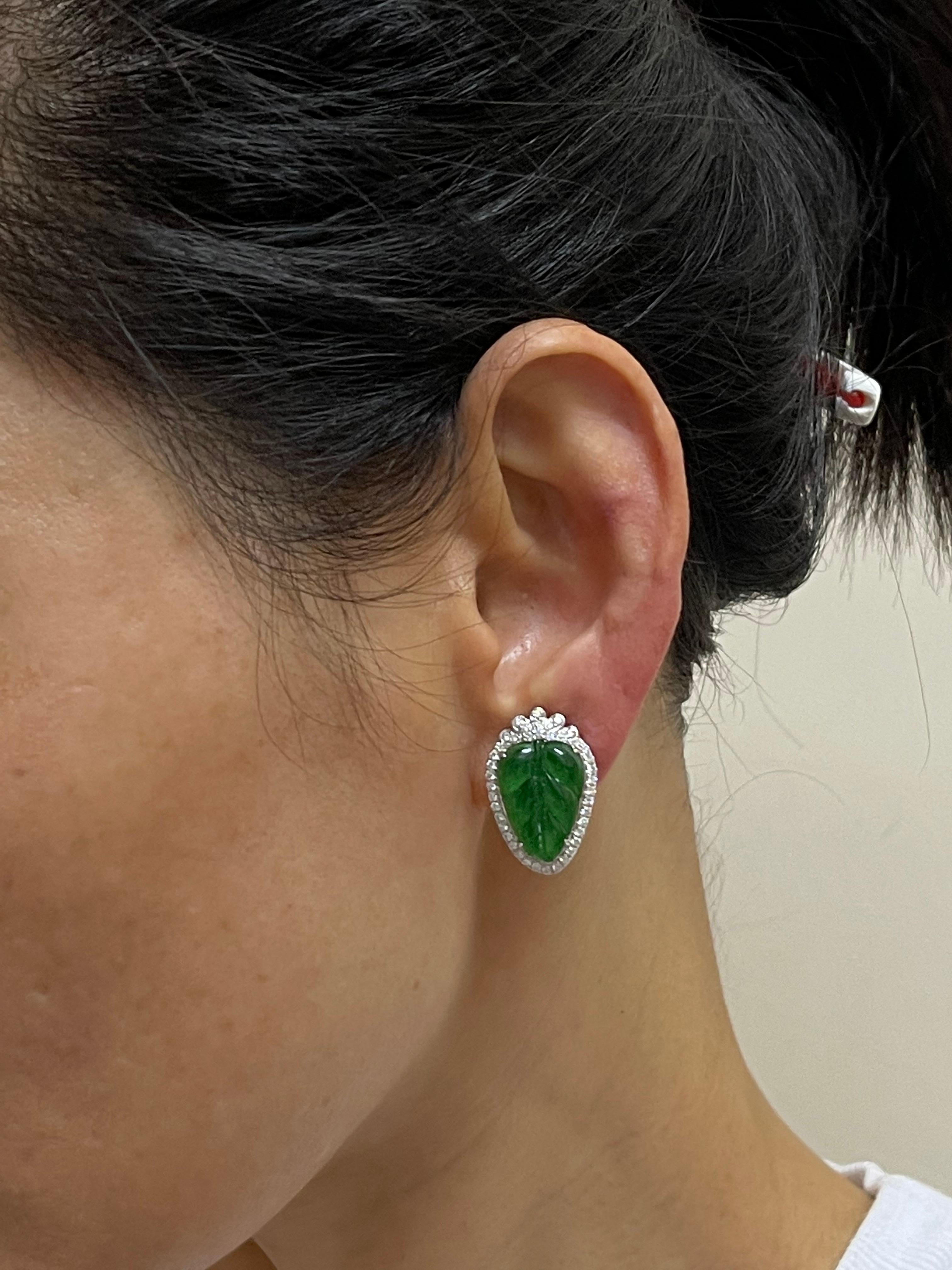 This is a very special pair of earrings. Made with the best imperial jade. They GLOW! The jade in these earrings are certified to be natural jadeite jade. The earrings are set in 18k white gold. There are 2 carved imperial green jade leaf motifs and