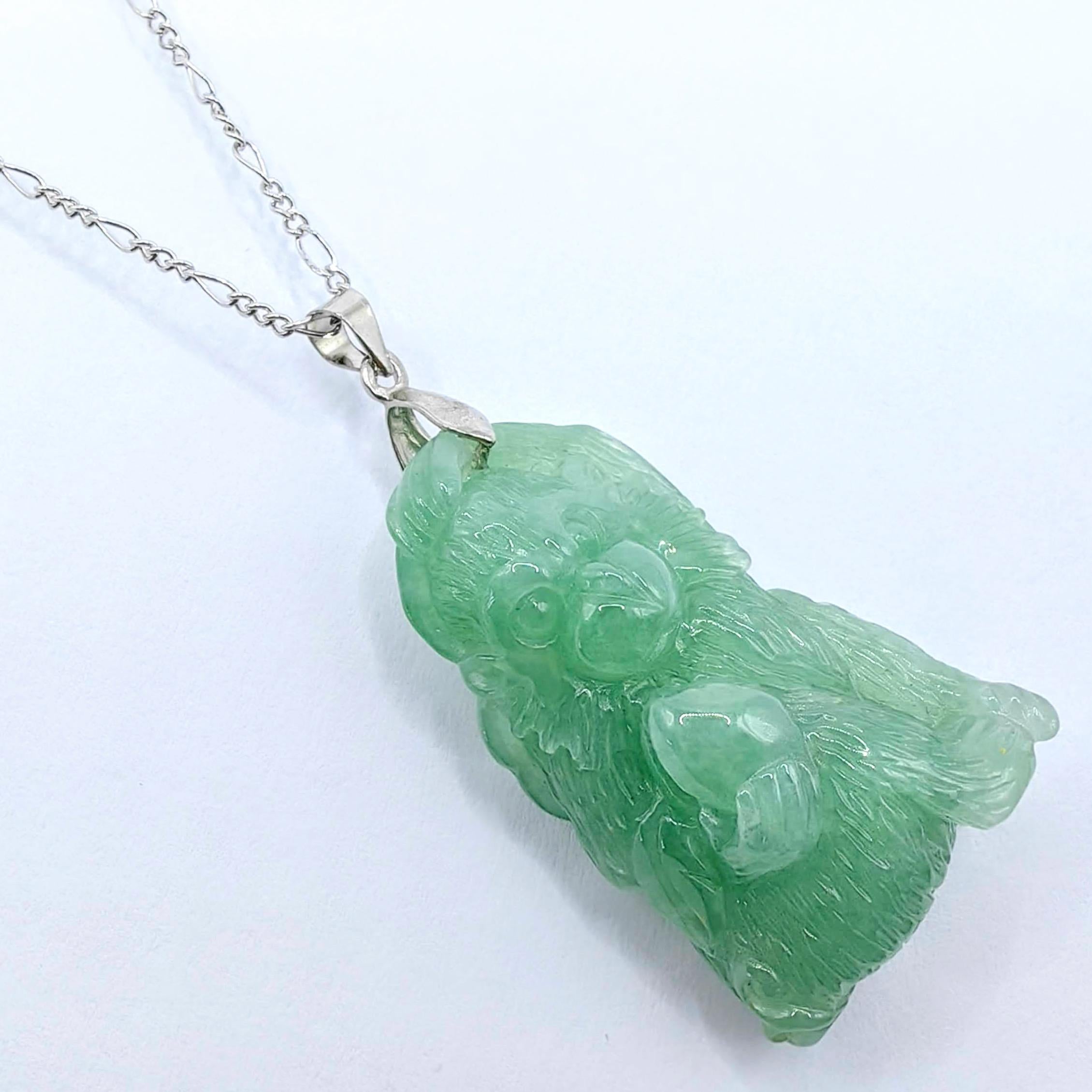 Embrassez la sagesse, l'espièglerie et les bénédictions de la longévité avec cet exquis pendentif singe sculpté en jadéite certifiée, magistralement sculpté à la main dans de la jadéite de la magnifique variété vert huileux (油青) et serti d'une