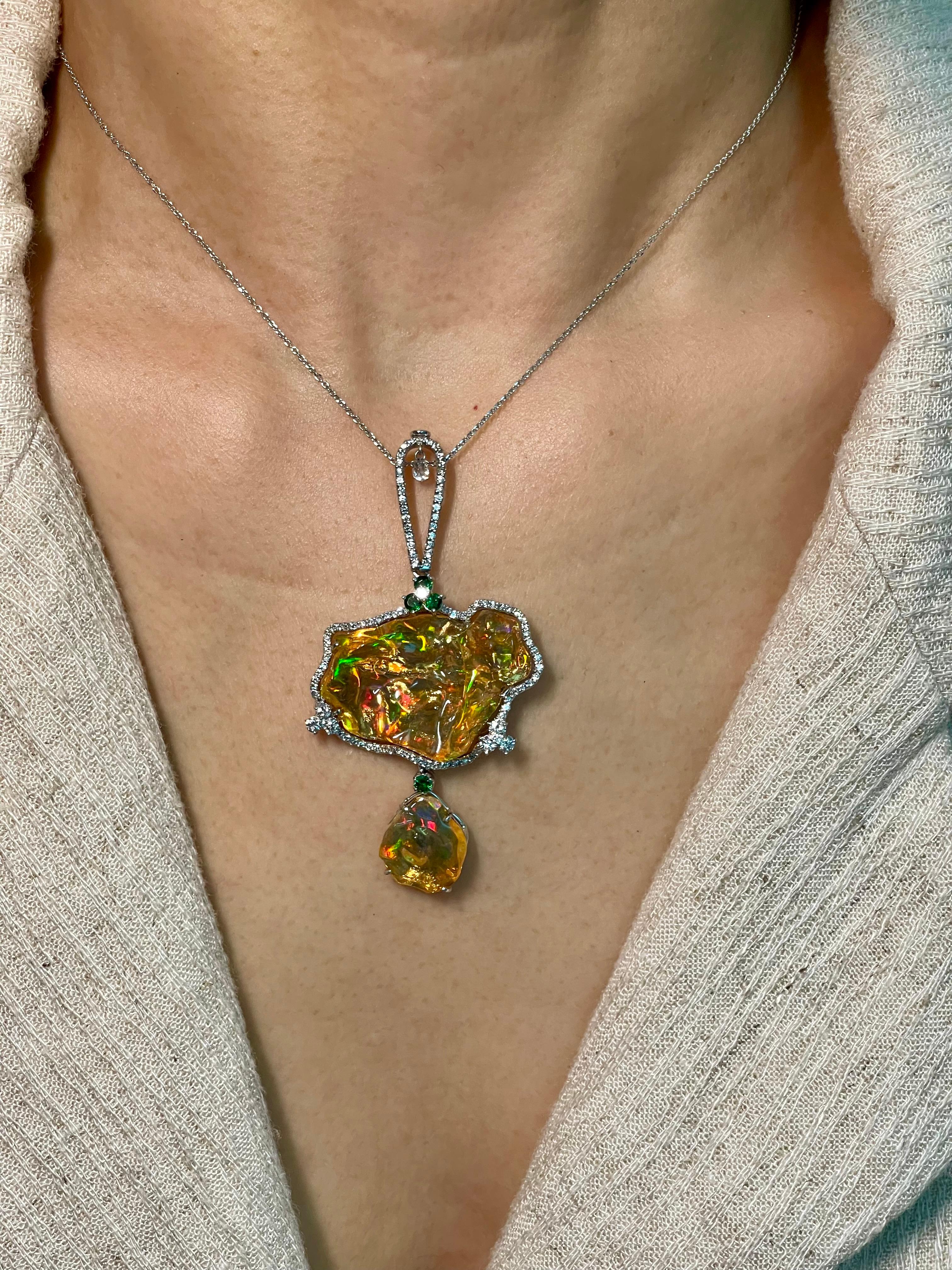 This is a nice substantial statement piece! 2 pieces of top gem quality opals make up this large pendant.   The natural Mexican fire opals are complimented by Tsavorites and white diamonds. The opals have superb play of colors. The natural opals in