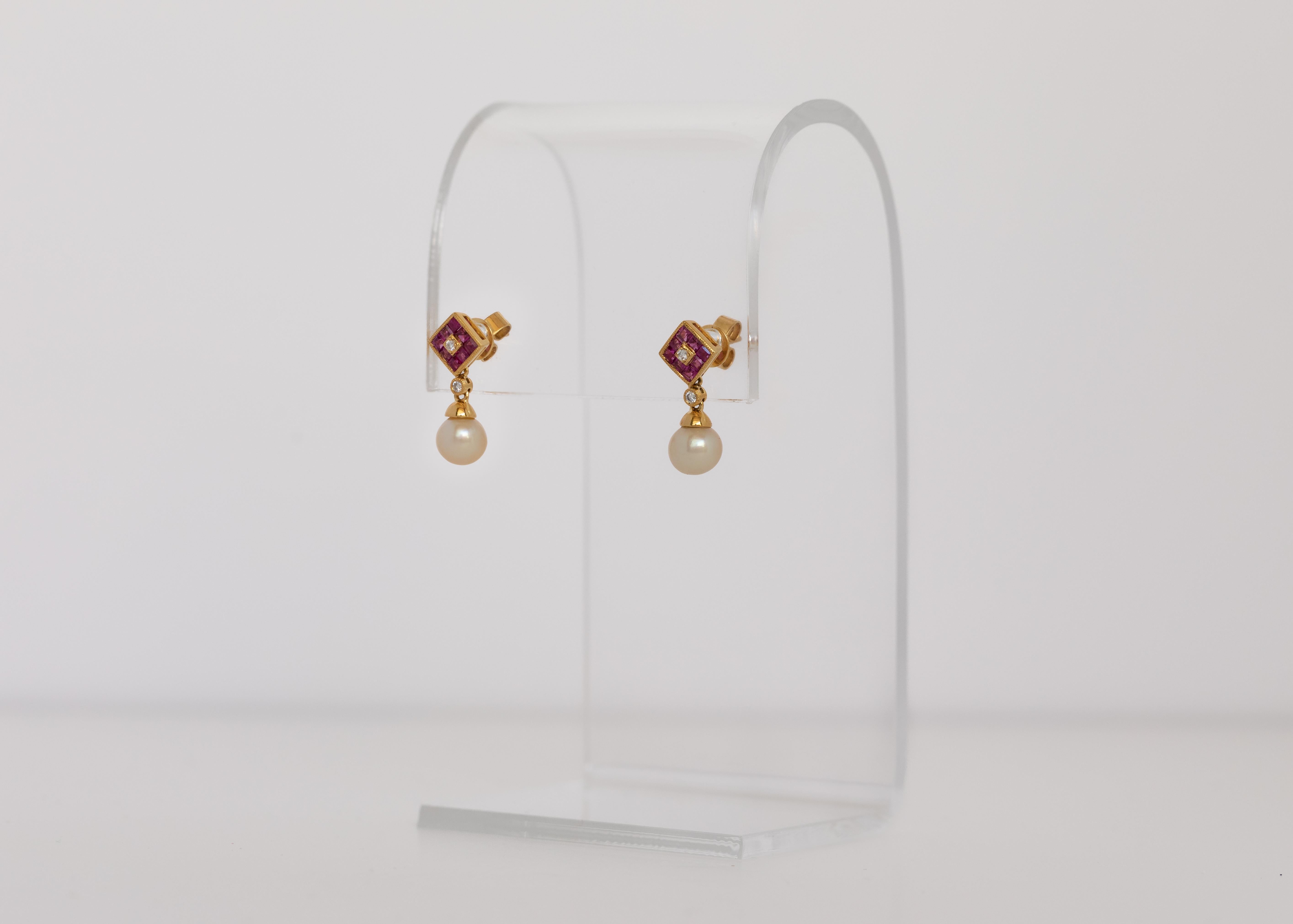 An every day wear, or for a special a occasion.

Those very high lustre, near round, certified natural Bahraini pearls hang from diamond shaped motifs studded in square cut rubies and round diamonds.

The earrings are in 18 karat yellow gold and are