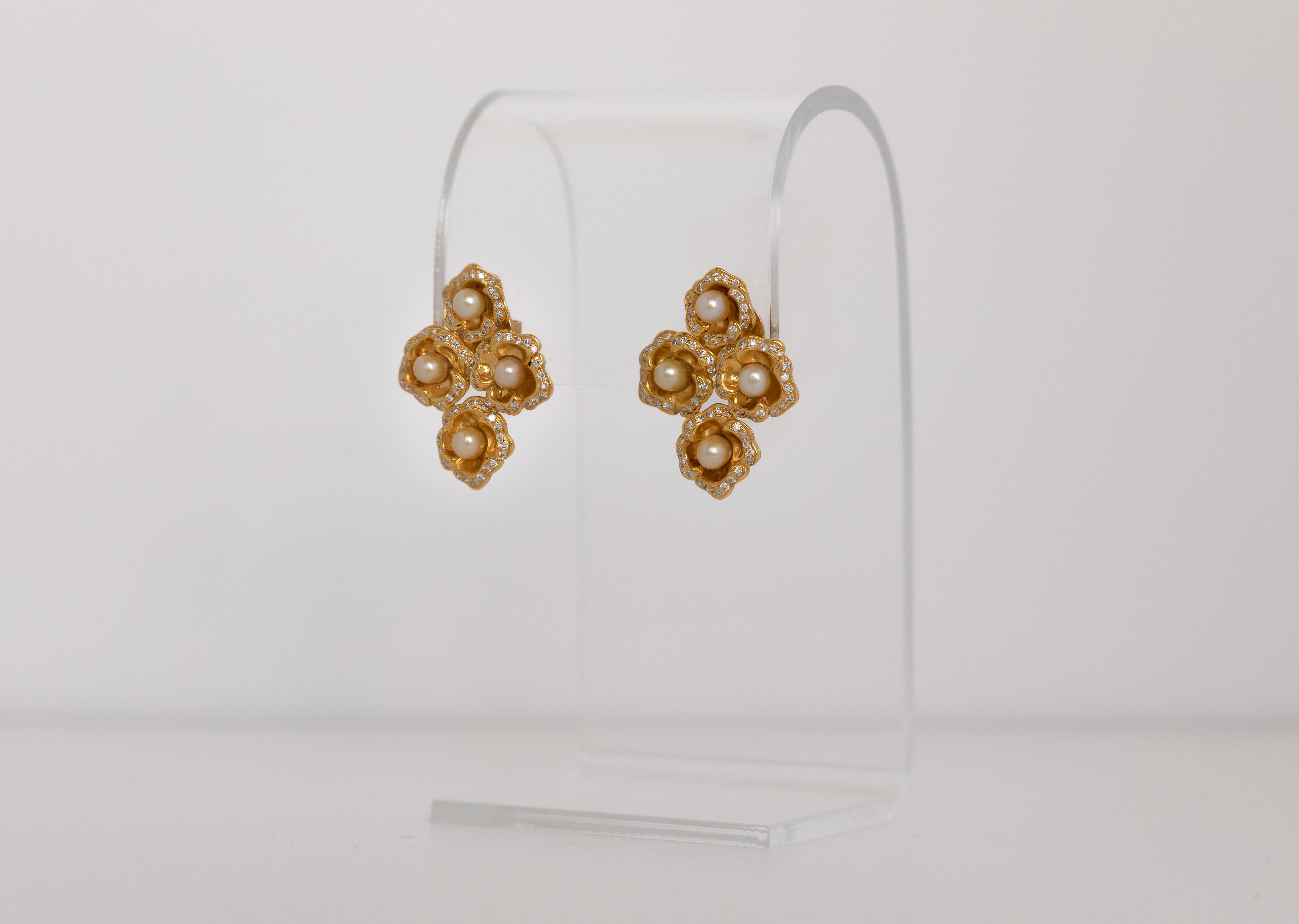 Intricately crafted 18 karat yellow gold flowers centered with certified natural Bahraini pearls with diamond studded rims.

Unique and one a kind earrings designed and manufactured in Bahrain.

Gold weight : 13g
Pearls: 5 ct.
Round Diamonds: 0.10