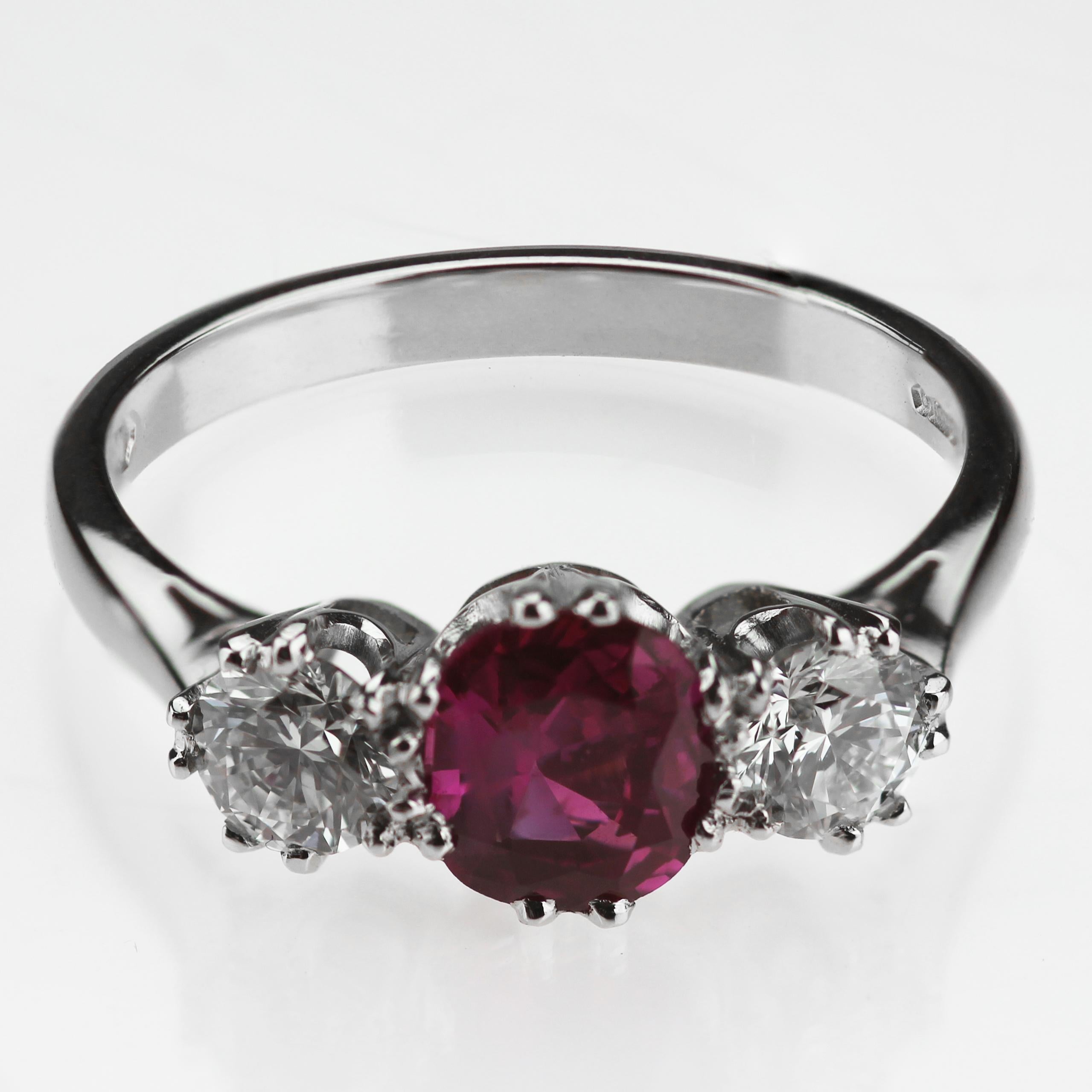 Certified Natural Burmese ruby and round brilliant cut diamond ring. Two brilliant cut diamonds -glistening and glowing on each sides of the ruby to complement the beautiful colour of the ruby set in platinum.
UK ring size 