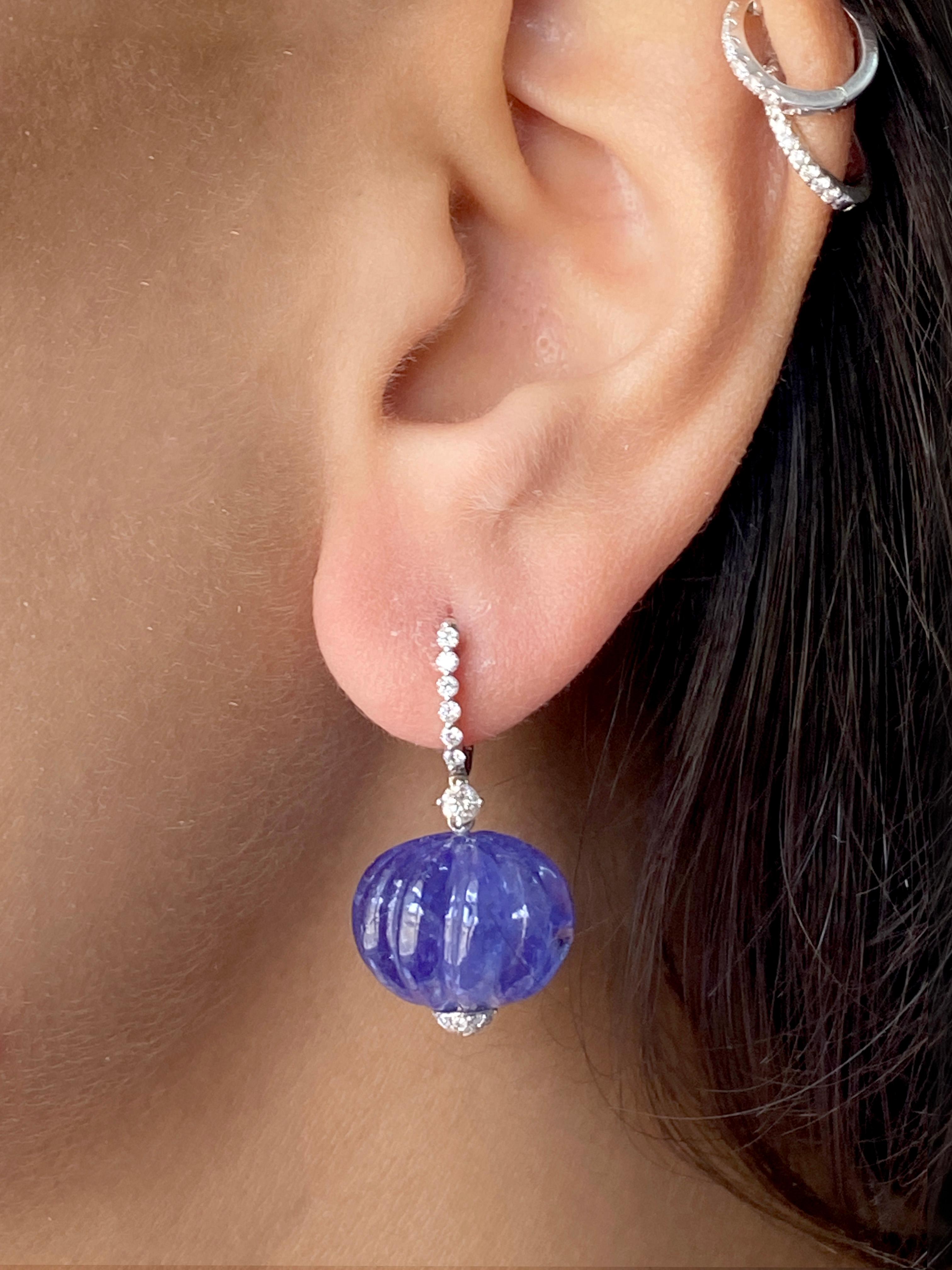 Feel unique and ethereal in with these Tanzanite Carved Drop Dangle Earrings! These earrings are carefully crafted in 18 karat white gold with two melon shaped, carved genuine tanzanite on the bottom, that are the showcase of these charming