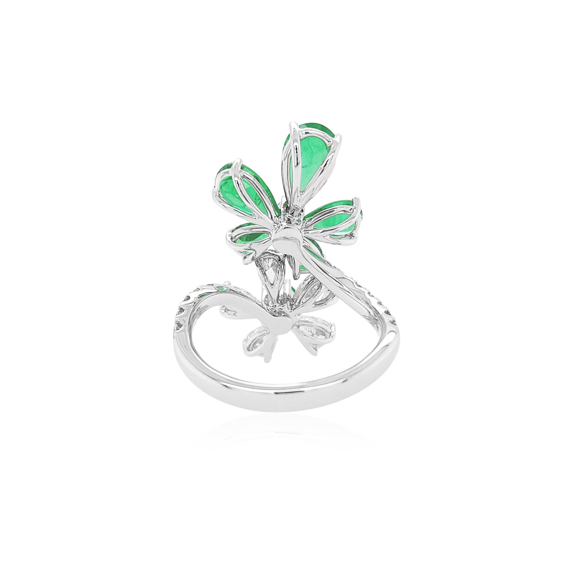 This intricate 18K White Gold cocktail ring features high-quality Colombian Emeralds set amongst scintillating white diamond floral motif. Unique and striking, this exceptional ring will add a touch of high glamour to any look. A fantastic addition