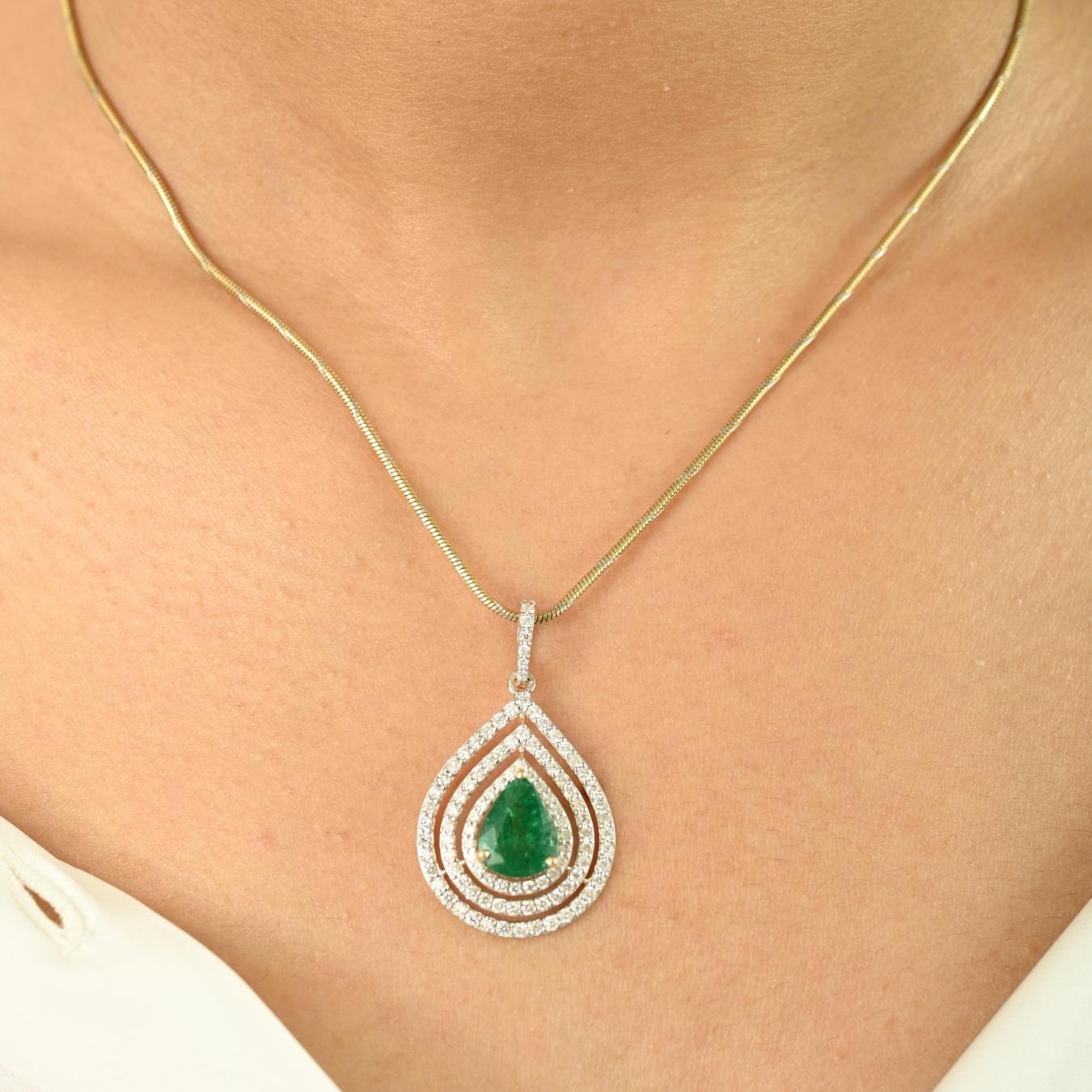 Élevez votre élégance avec cet exquis pendentif en émeraude, réalisé en luxueux or jaune 18 carats. Doté d'une captivante émeraude en forme de poire de 2,45 carats en son centre, le pendentif est gracieusement entouré de trois halos en forme de