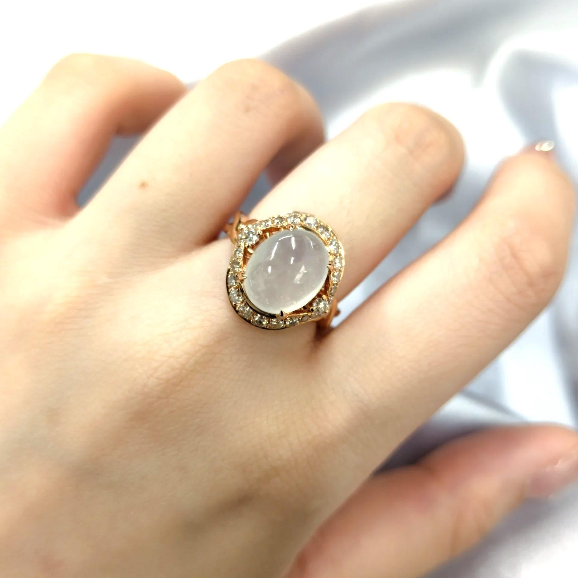 This exquisite ring showcases a stunning piece of Certified Natural Type A White Jade, a highly prized gemstone known for its translucency and purity. The jade is set in a classic oval cabochon cut, allowing its natural beauty and luster to