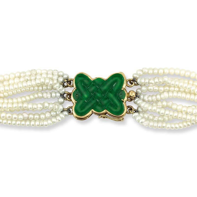What an elegant and classic piece! Rich natural green jadeite jade endless knot carving makes up the centerpiece and clasp for this necklace that supports a 9 fresh water pearl strands. The necklace is 17 inches in length. The pearls are
