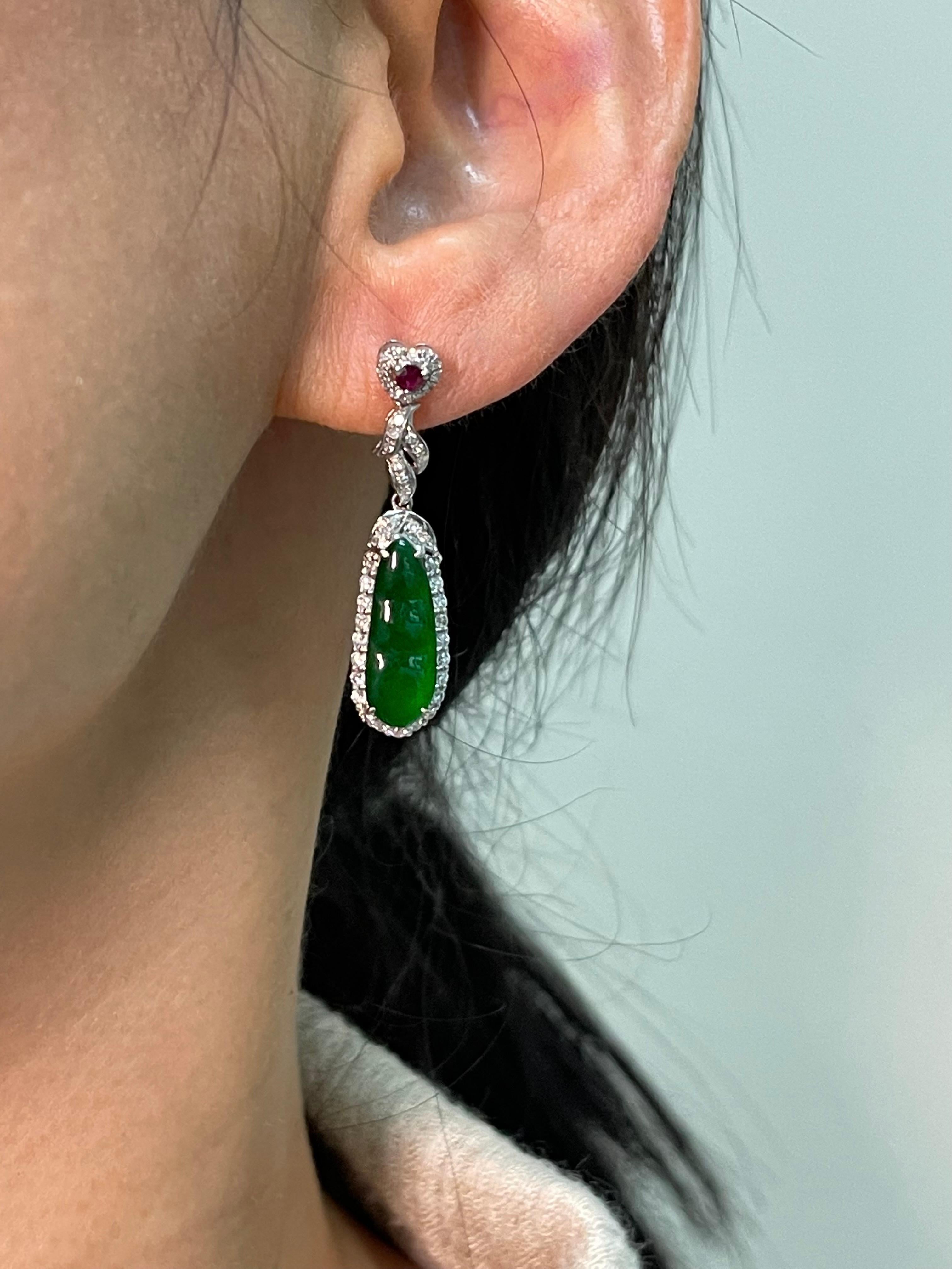 Please check out the HD video! These icy imperial green jade earrings are certified by 2 labs. The earrings are set in 18k white gold, rubies and white diamonds. The 2 jade peapods glows. The imperial  jade peapod carving represents safety all year