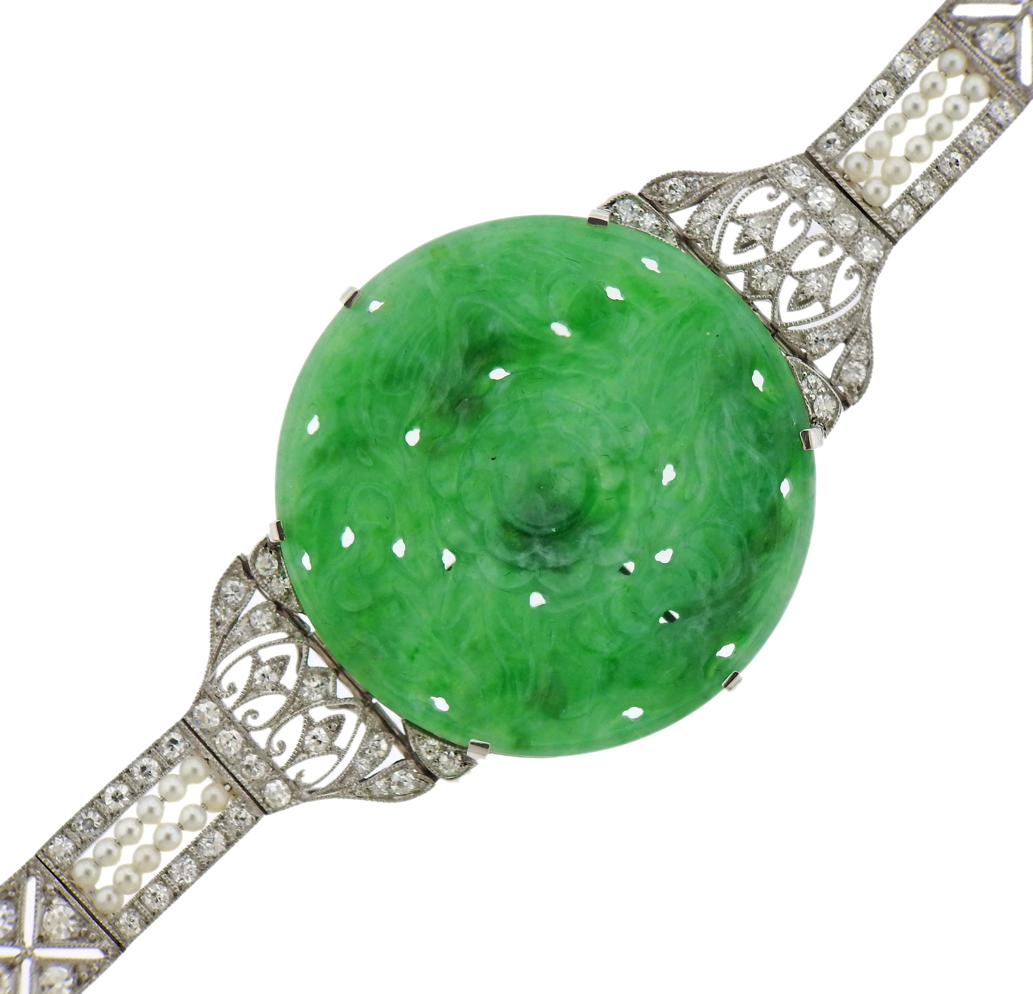 Gorgeous Art Deco platinum bracelet, with center 36mm certified carved natural jadeite jade, surrounded with 1.3-1.5mm pearls and approx. 1.50ctw in diamonds. Bracelet is 7