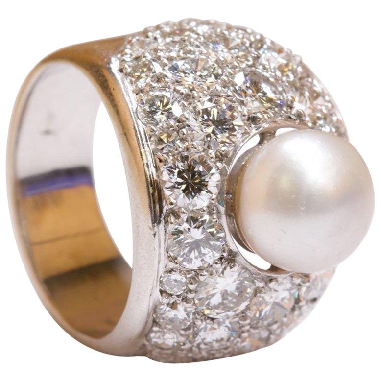 This absolutely stunning 14K white gold pearl and diamond ring is sure to catch the attention of anyone who comes into contact with you. It is set with a button-shaped natural pearl, measuring approximately 8.5 x 8.8 x 6.4mm, which has a wonderful