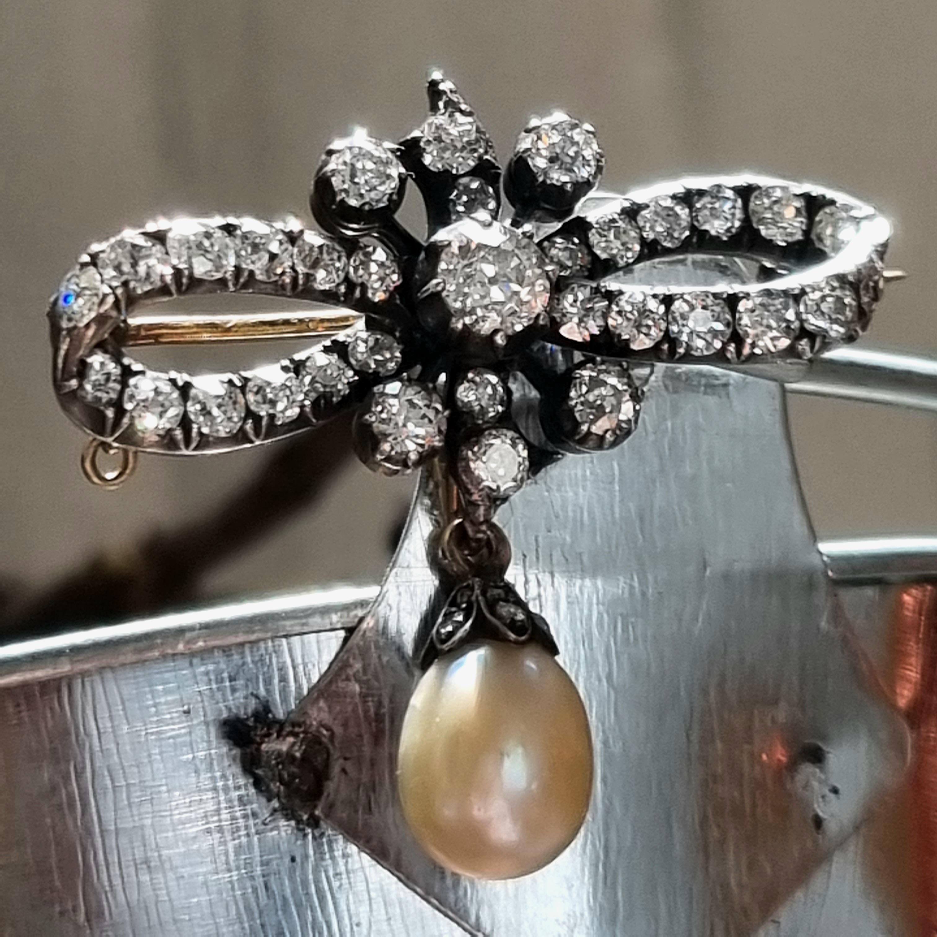 VICTORIAN NATURAL SALTWATER PEARL AND DIAMOND BOW BROOCH (late 19th Century) (GIA Lab report and Gem & Pearl Lab report)
Certified Natural Saltwater Pearl and Diamond Brooch 19th Century.
Suspending a Natural Saltwater pear-shaped Pearl, measuring