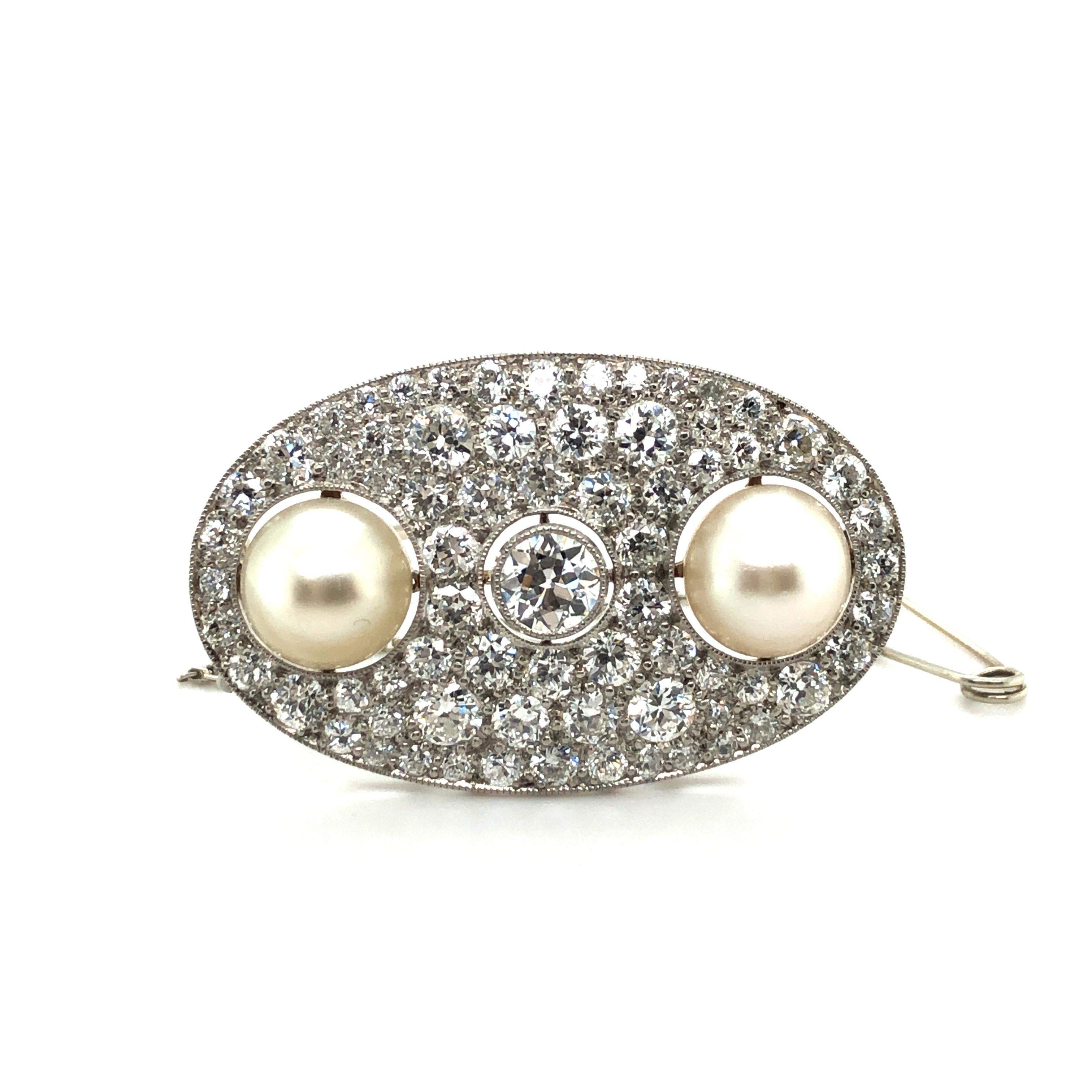 Gorgeous oval shaped Art Déco brooch in exquisite condition.

Center set in a fine mille griffe with a 0.60 ct old European-cut diamond of G/H-vs quality. Flanked by two slightly button-shaped natural saltwater pearls of 9 mm in diameter. The SSEF