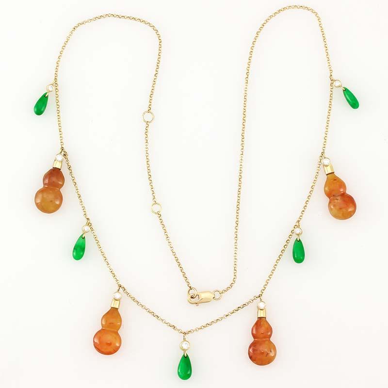 This exceptional Mason-Kay designer necklace features four matching vivid red/orange jade Hulu carvings and 5 vivid apple green jade tear drops all set with round diamond tops hanging on a 14K yellow gold chain. The chain is 18 inches long but the
